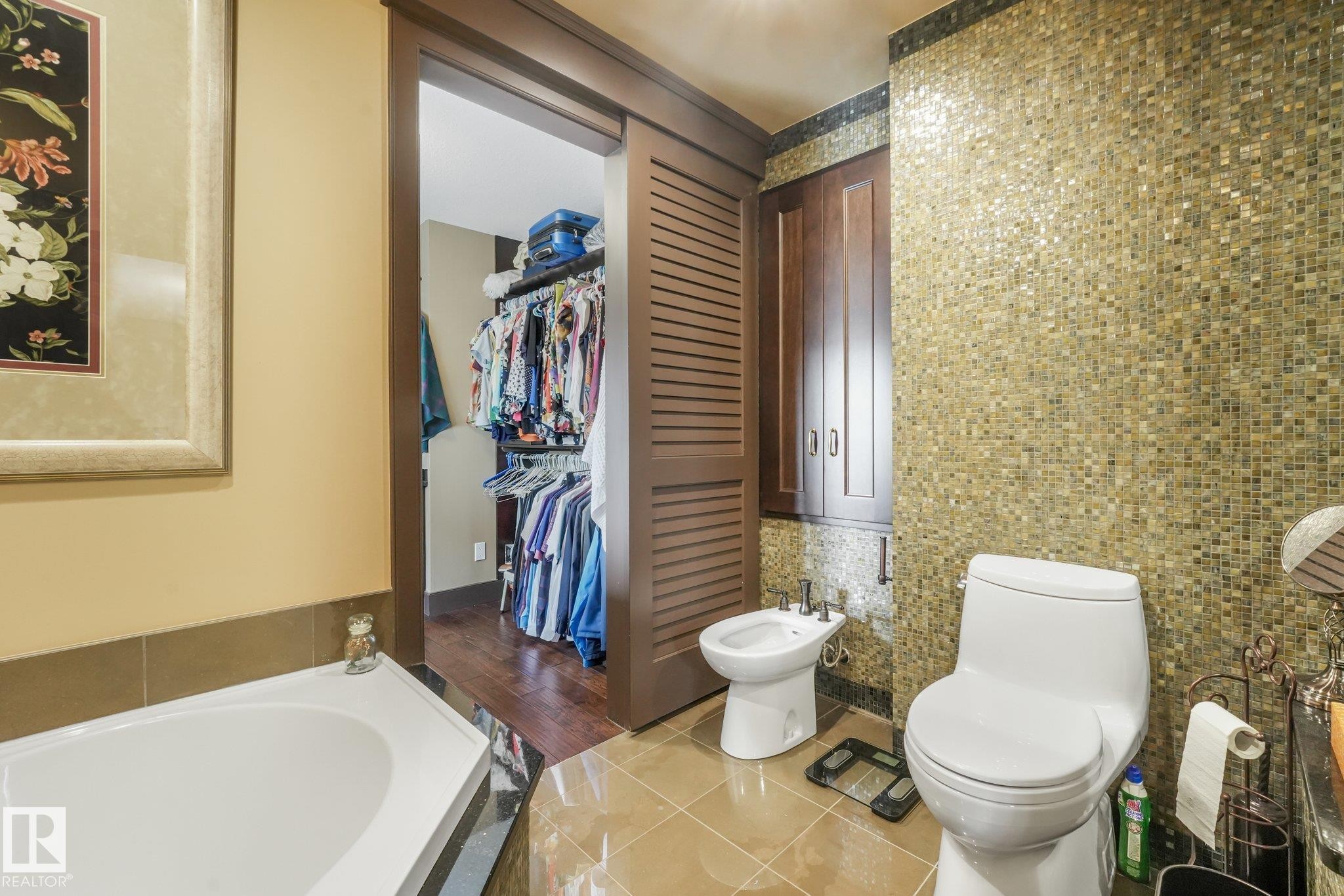 Built-in storage cabinetry, mosaic tile accent wall, and a separate bidet - 12827 150 Avenue Nw, Edmonton, AB