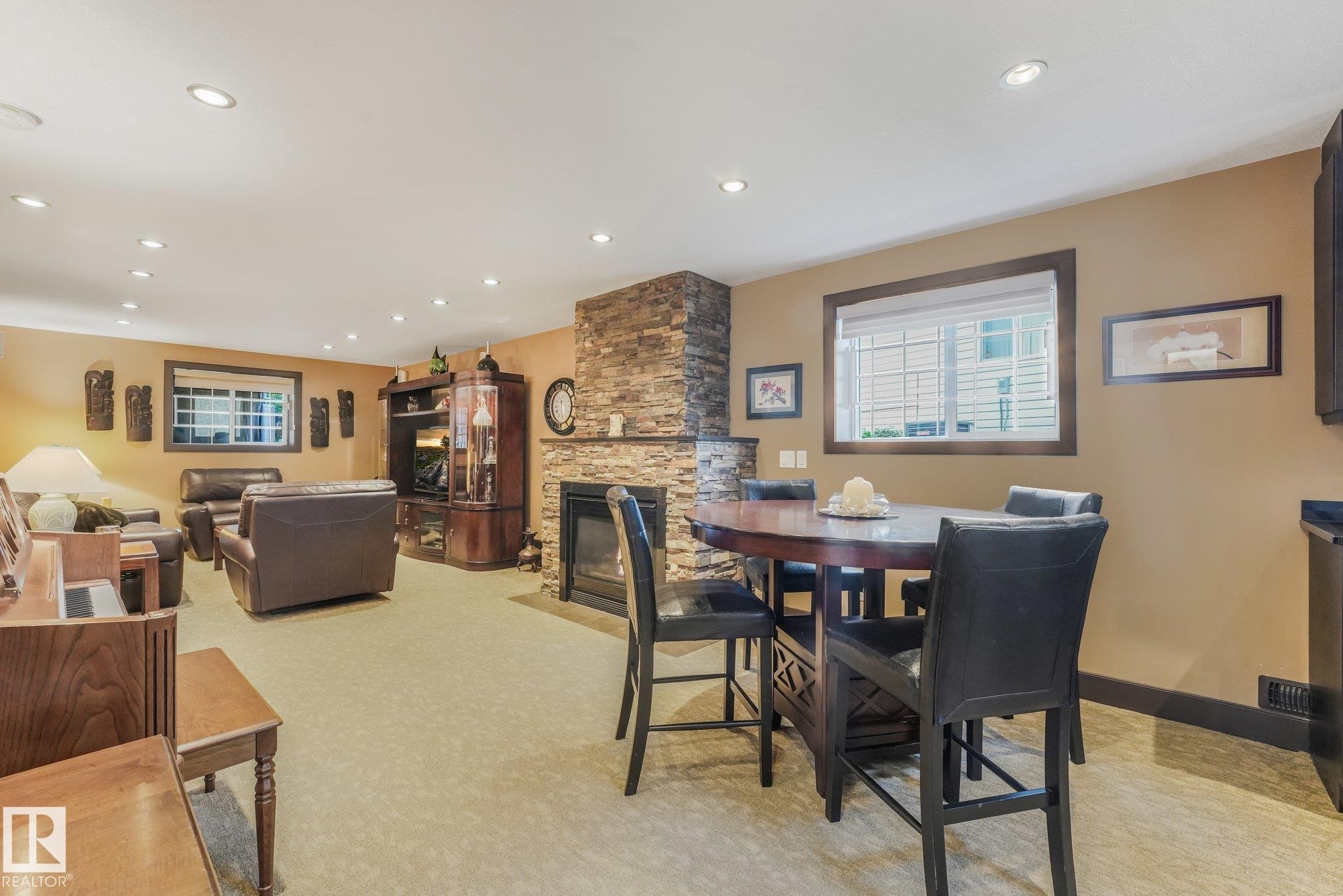 Recessed lighting, stone-front fireplace, light-toned carpeting, and wood-trim windows - 12827 150 Avenue Nw, Edmonton, AB