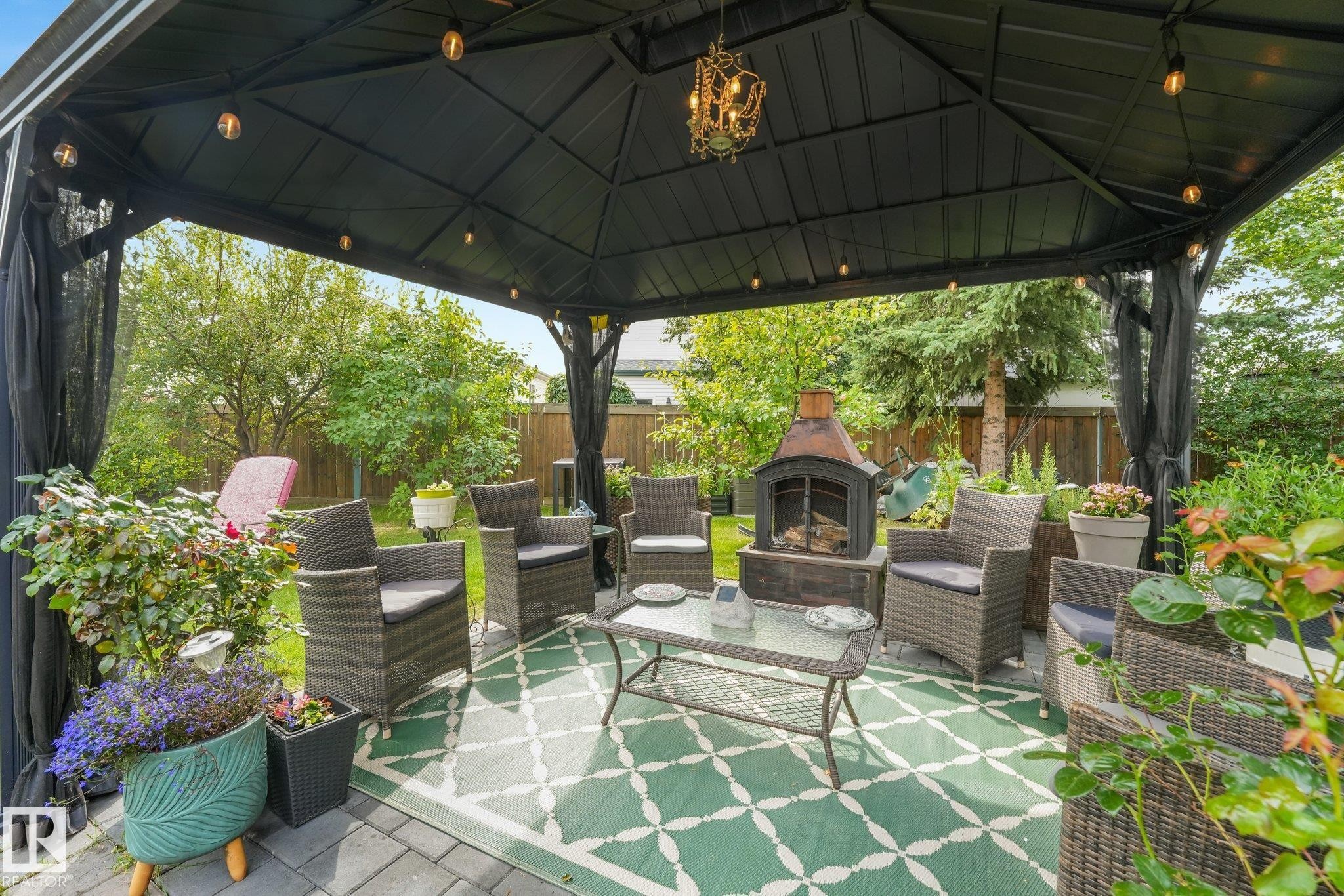 Black metal gazebo featuring a decorative chandelier and string lighting - 12827 150 Avenue Nw, Edmonton, AB