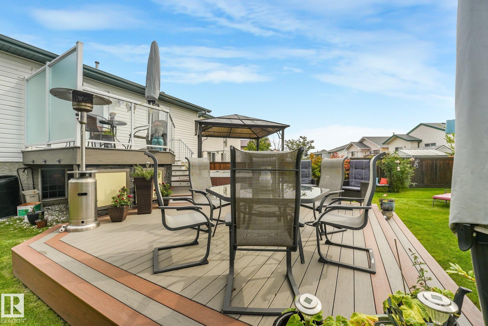 Multi-level composite deck with glass panel railing and integrated steps - 12827 150 Avenue Nw, Edmonton, AB