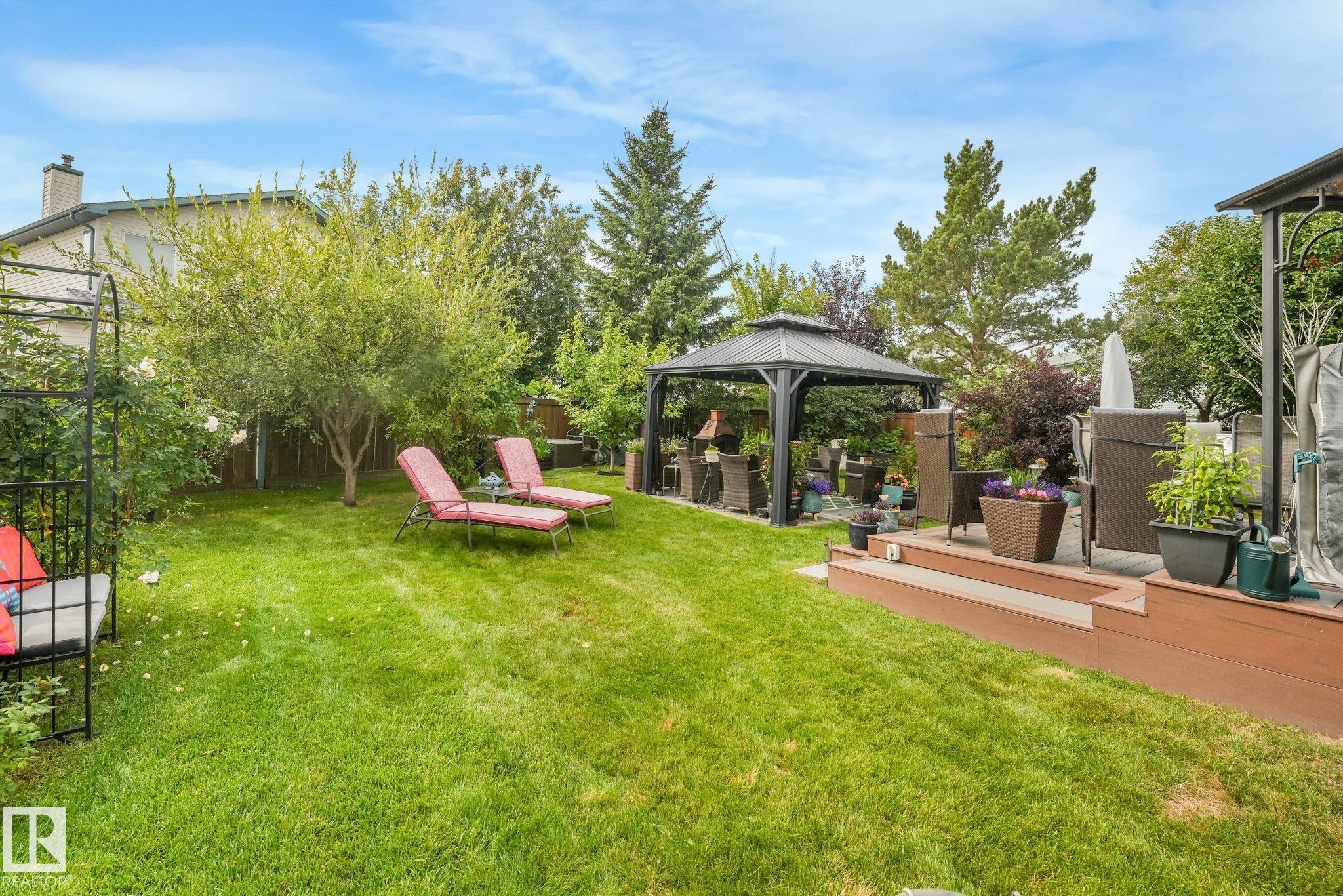 Expansive lawn area, mature trees, tiered wood-finish decking, and built-in gazebo - 12827 150 Avenue Nw, Edmonton, AB
