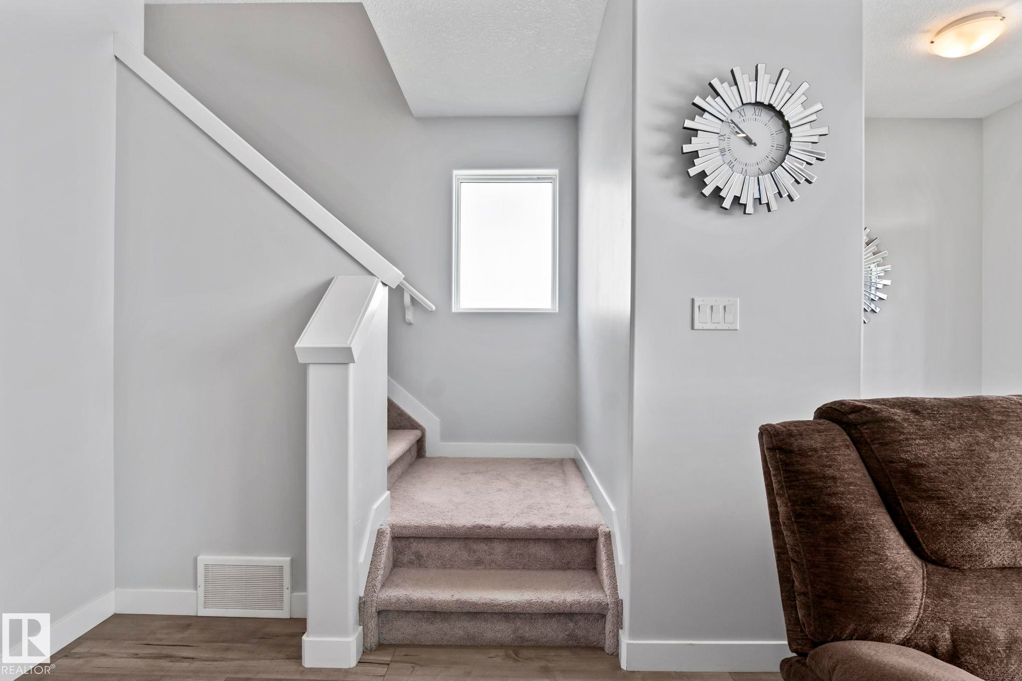 Carpeted staircase with white newel post and handrail - 10338 162St Nw, Edmonton, AB