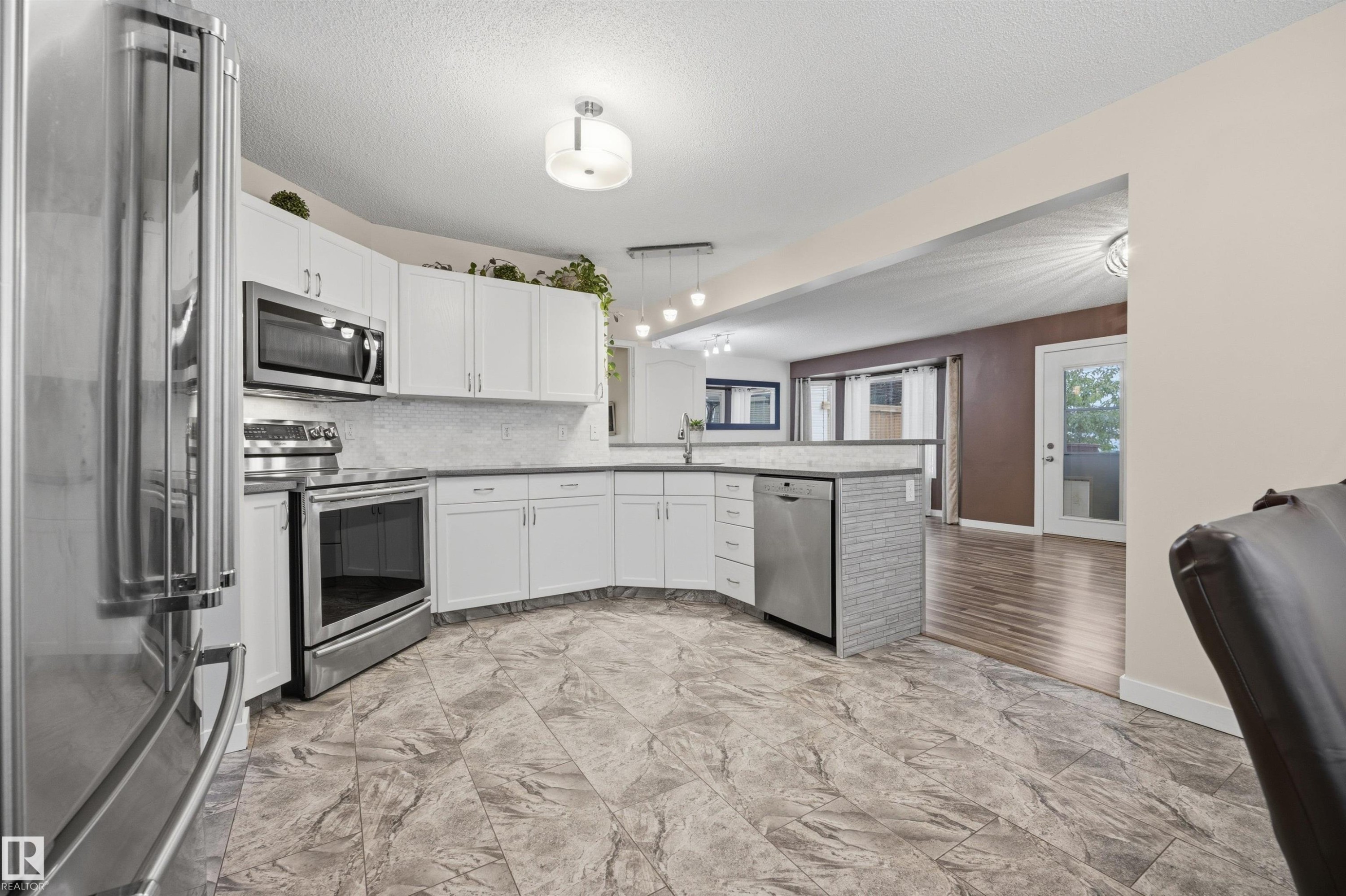 View of open-concept kitchen with updated appliances - 6910 158A Avenue Nw, Edmonton, AB