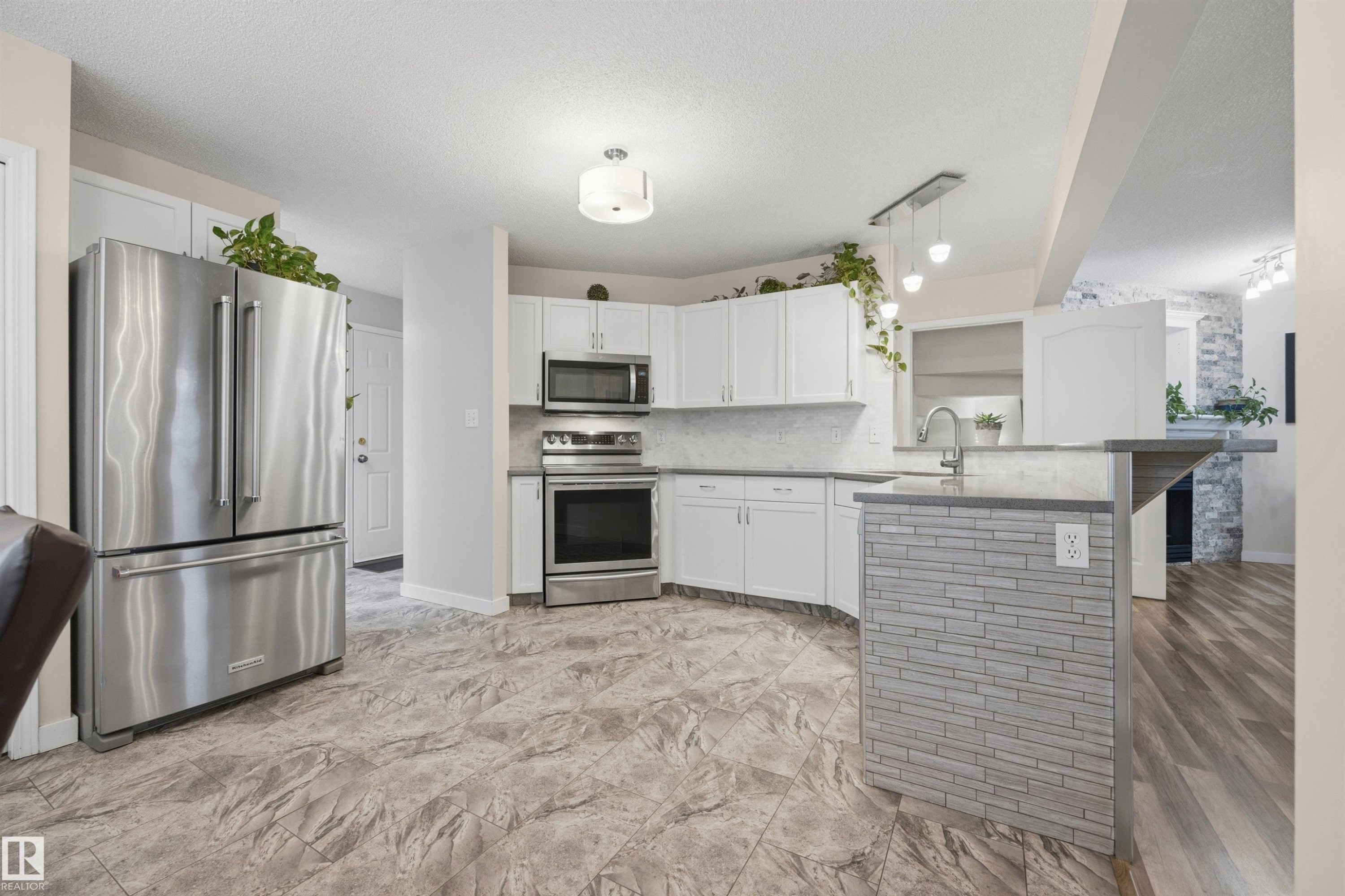 View of open-concept kitchen with updated appliances - 6910 158A Avenue Nw, Edmonton, AB
