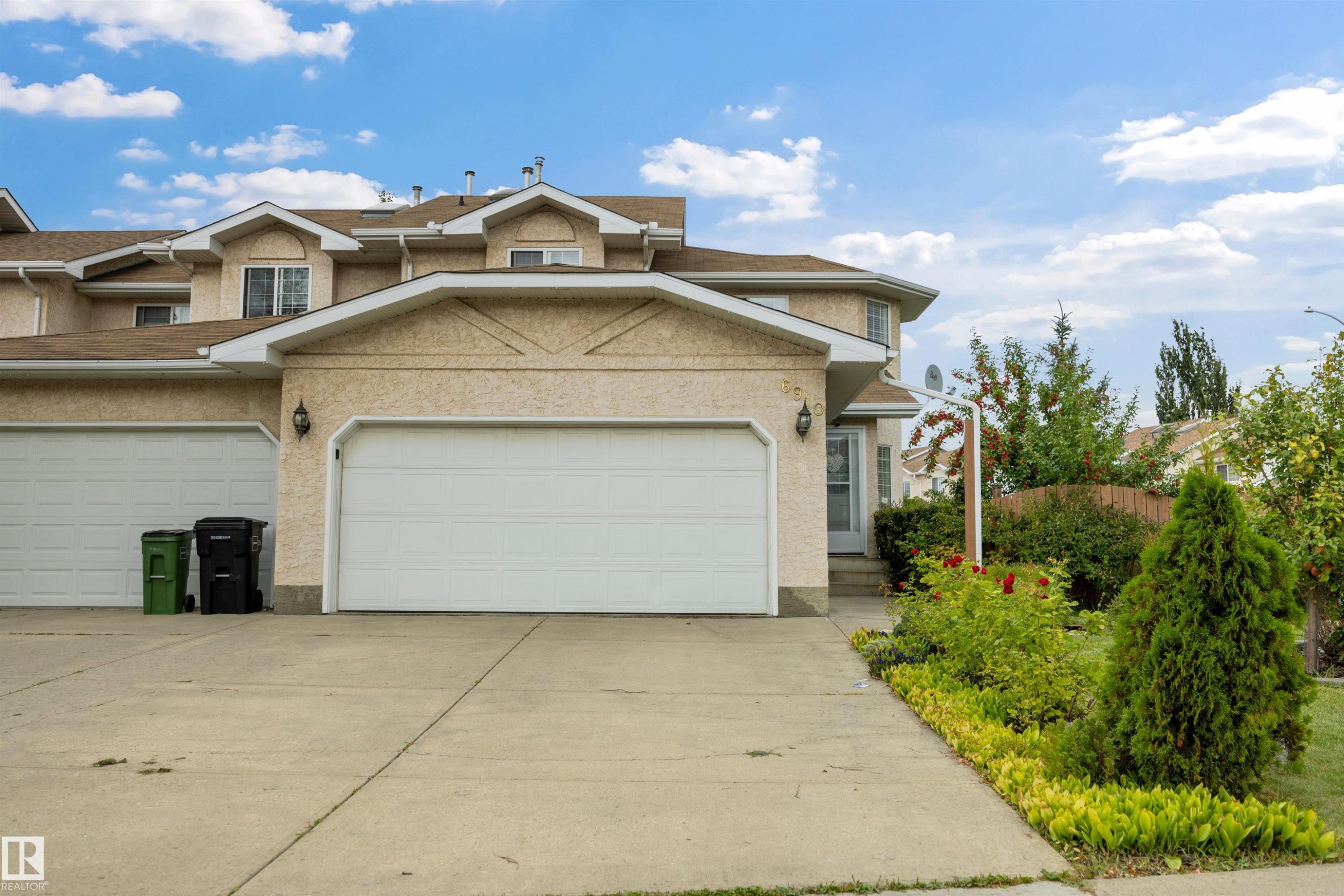 Front view of home with double attached garage and large driveway - 6910 158A Avenue Nw, Edmonton, AB