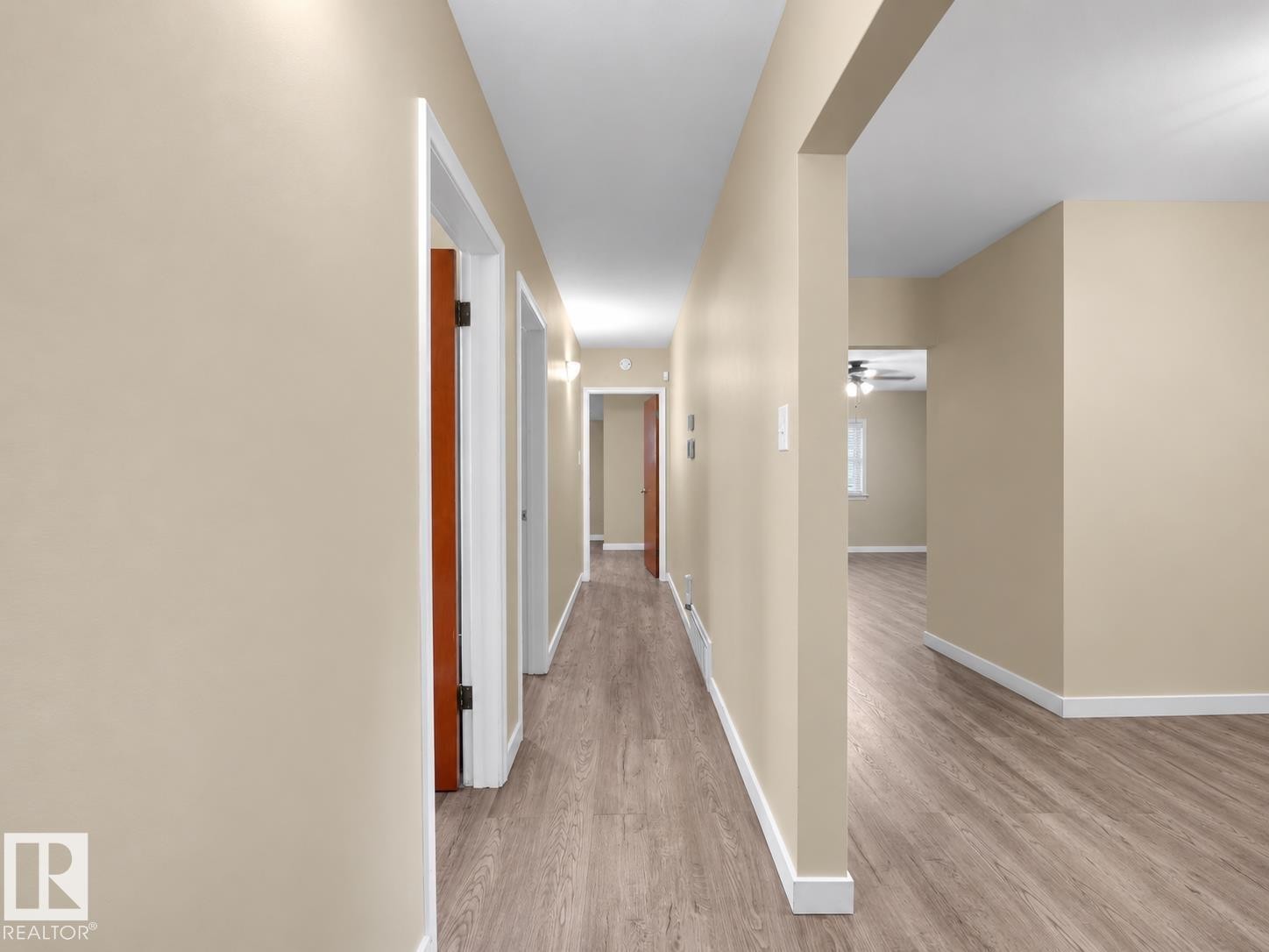 Hallway with wood-finish flooring, light neutral wall tones, and white trim - 12002 48 Street Nw, Edmonton, AB
