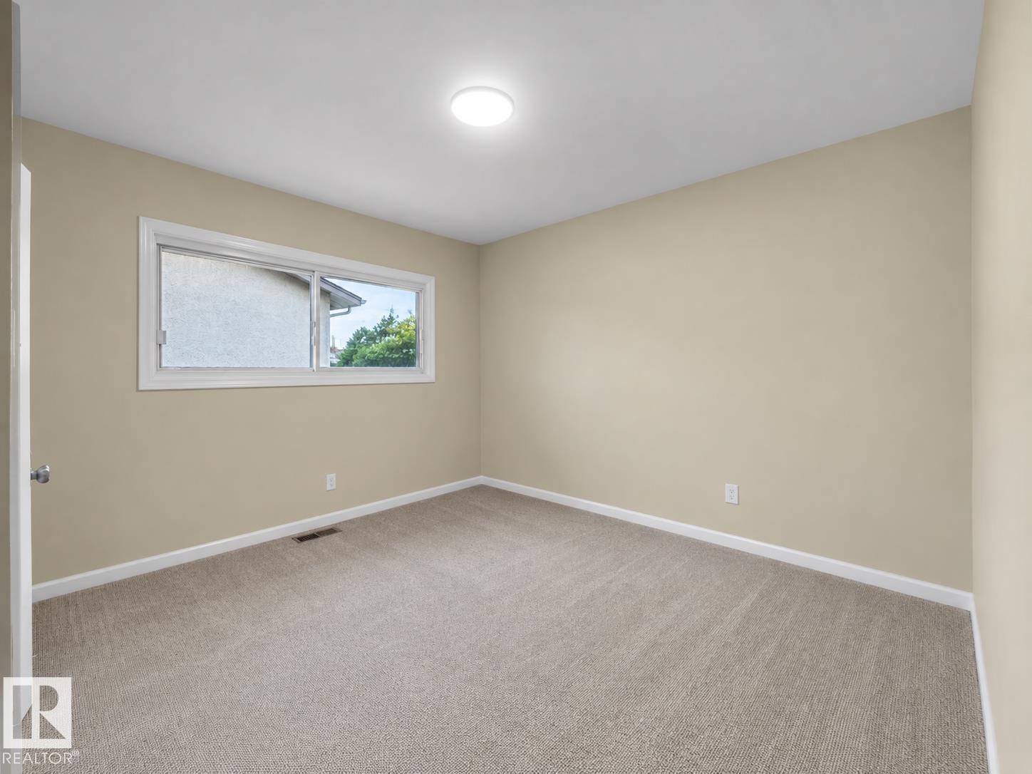 Neutral-toned walls complement the light-colored carpeting - 12002 48 Street Nw, Edmonton, AB