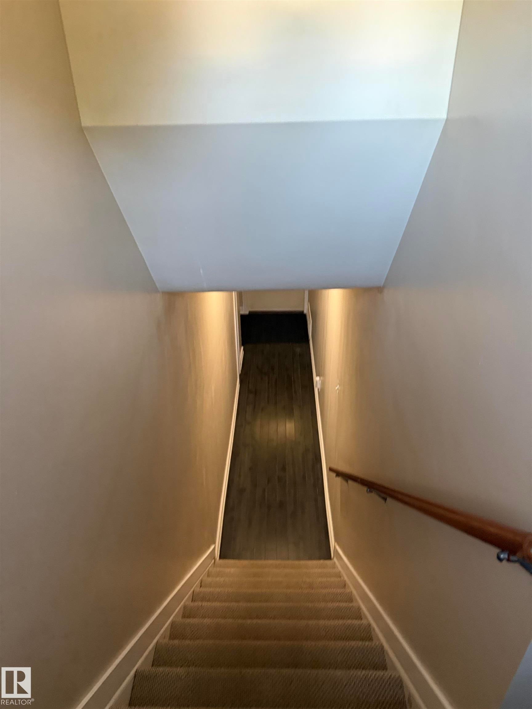 Carpeted staircase with a wood handrail and recessed lighting - 12002 48 Street Nw, Edmonton, AB