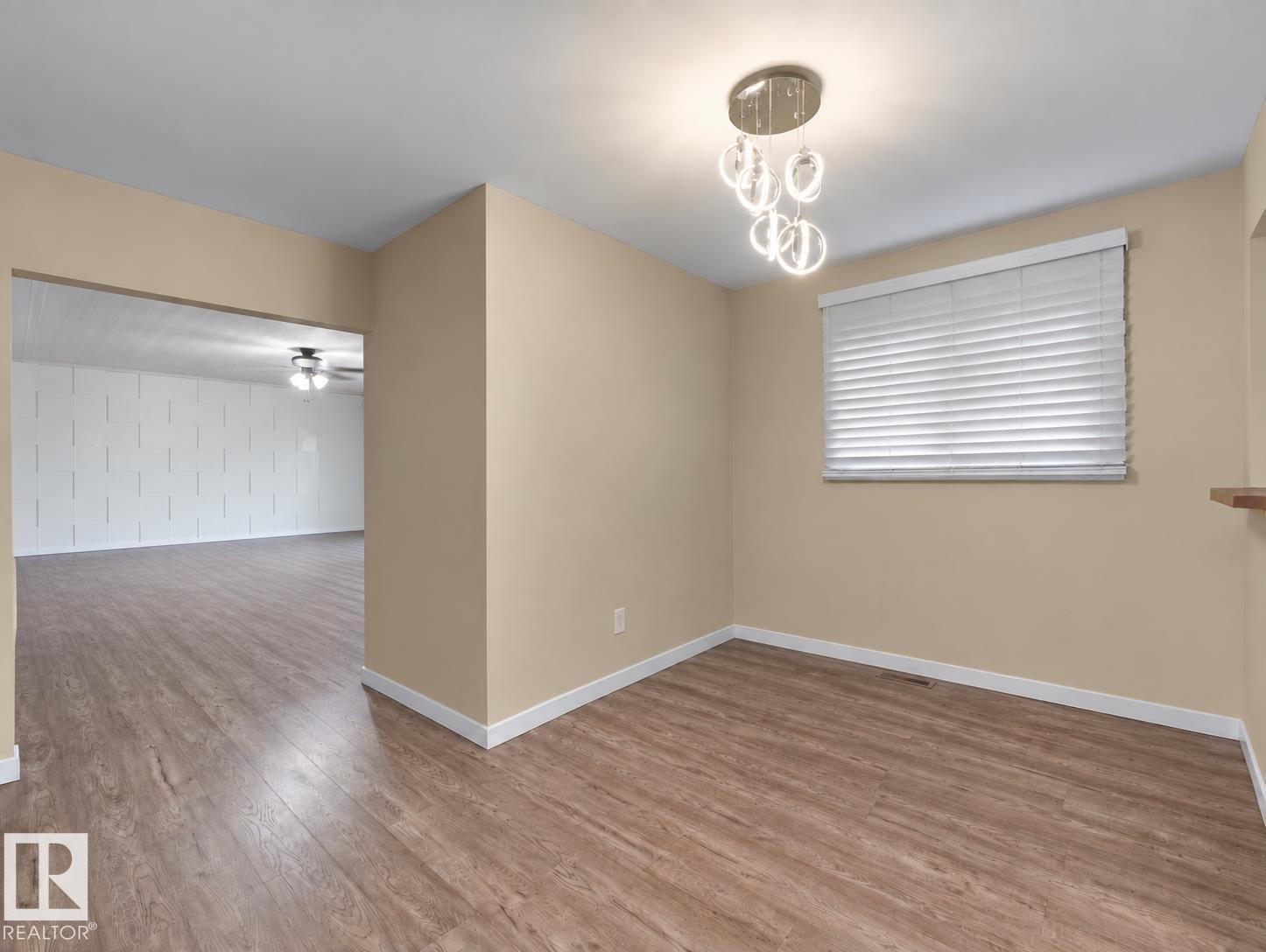 Wood-finish flooring throughout, modern chandelier, window with blinds, and neutral wall tones - 12002 48 Street Nw, Edmonton, AB