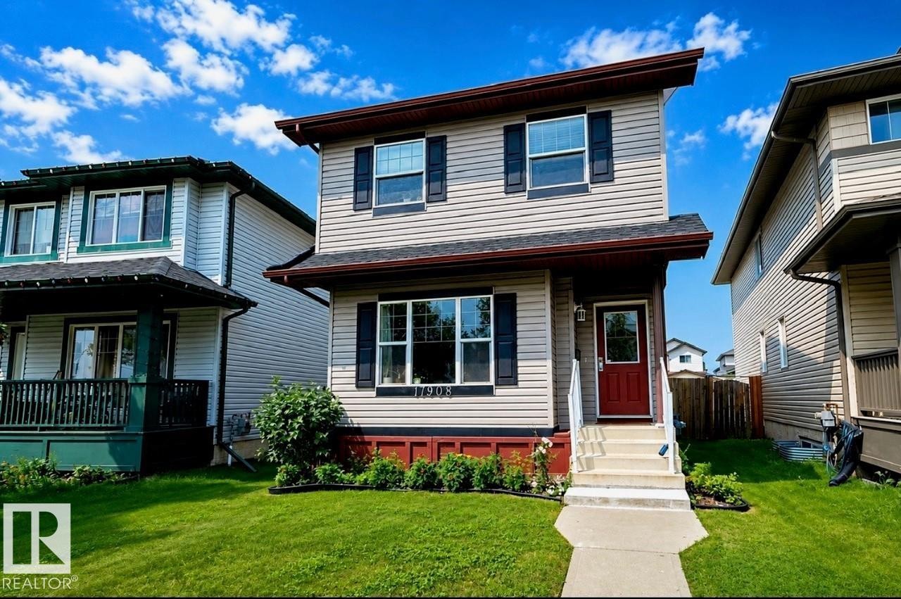 Two-story residence featuring light-colored siding, dark window shutters, and a contrasting dark red front door - 17908 89 Street Nw, Edmonton, AB - Outdoor With Deck Patio Veranda With Facade