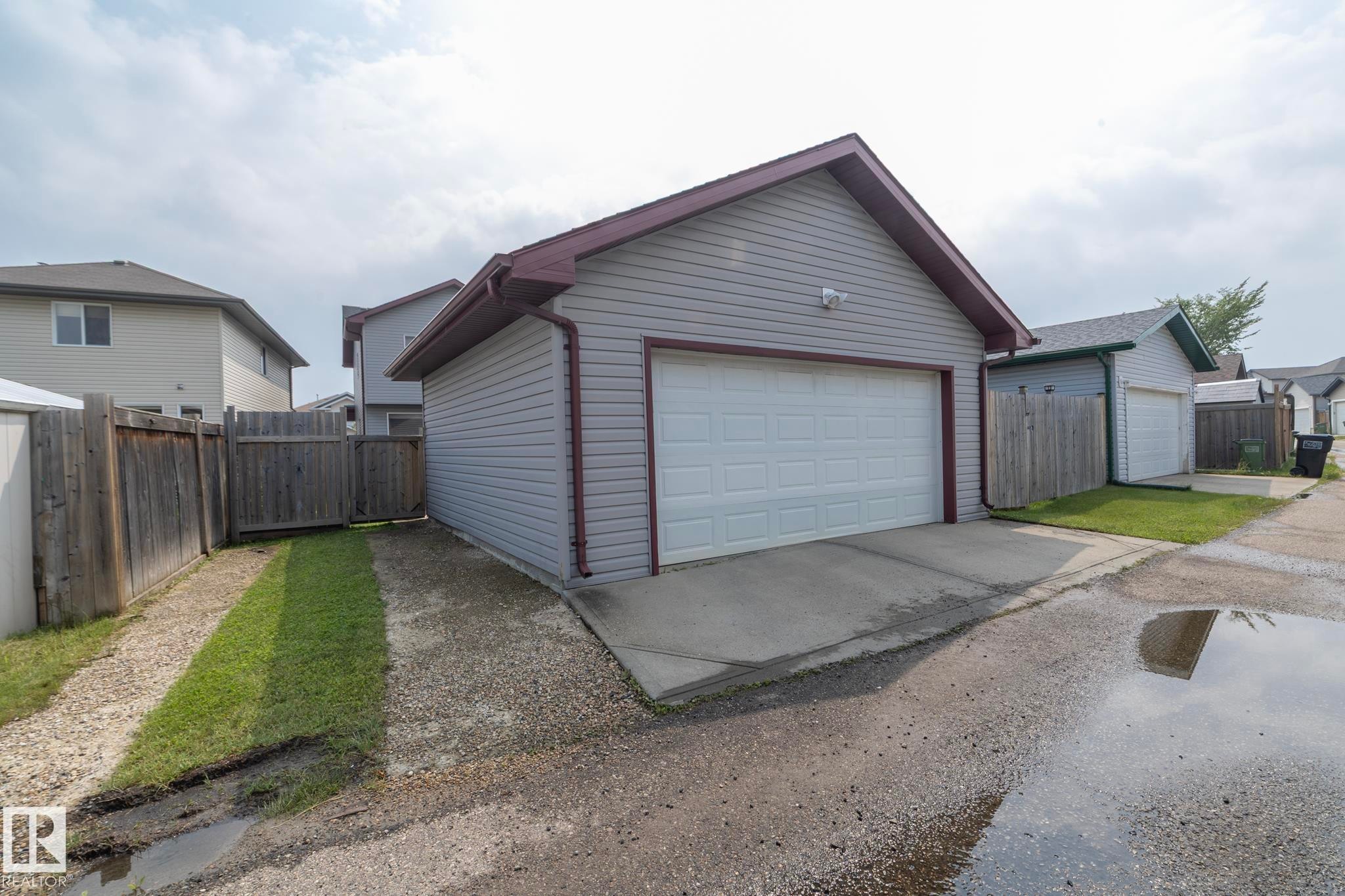 Detached garage featuring light grey siding, a white overhead door, and a brown trim roof - 17908 89 Street Nw, Edmonton, AB - Outdoor With Exterior