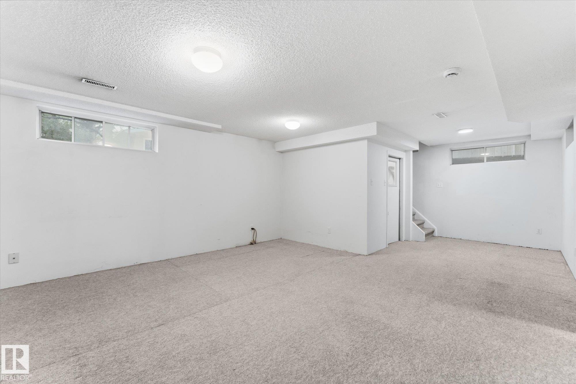 Carpeted flooring with white painted walls and ceiling - 11311 Malmo Road Nw, Edmonton, AB