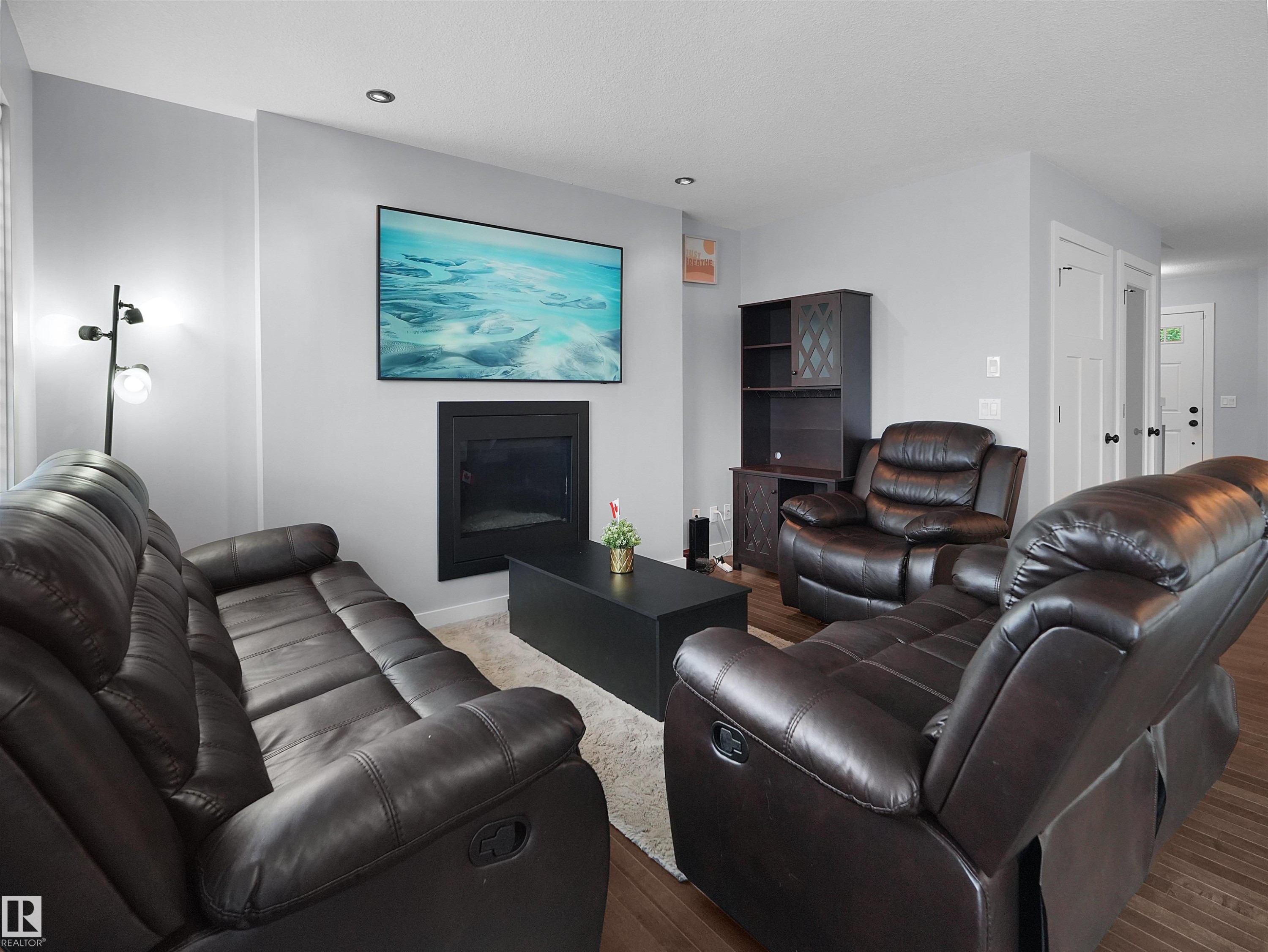 Recessed ceiling lighting, a contemporary fireplace, and a light gray wall finish - 6656 Cardinal Rd Sw, Edmonton, AB