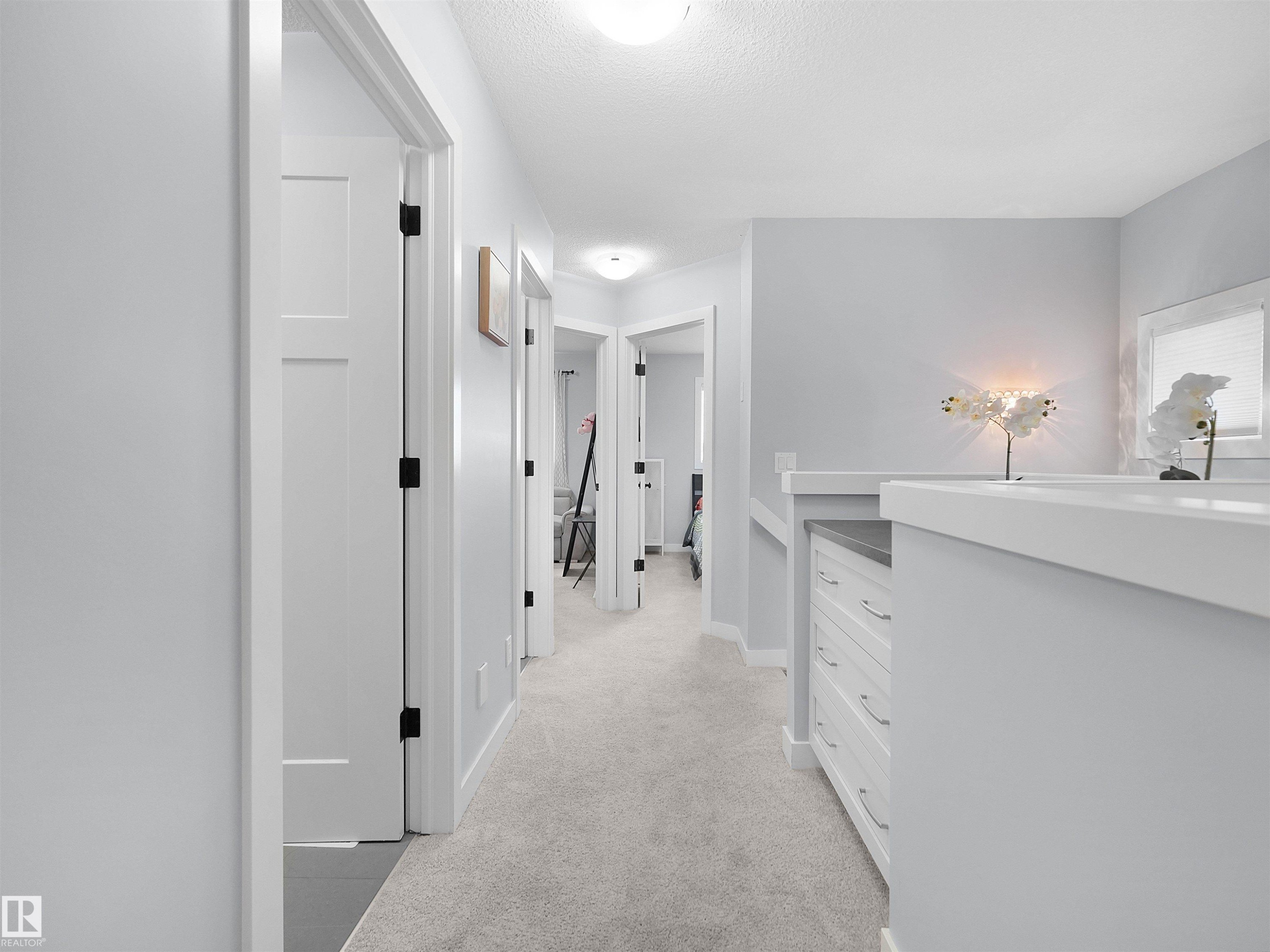Plush carpet flooring, recessed lighting, and white paneled doors with matte black hardware - 6656 Cardinal Rd Sw, Edmonton, AB