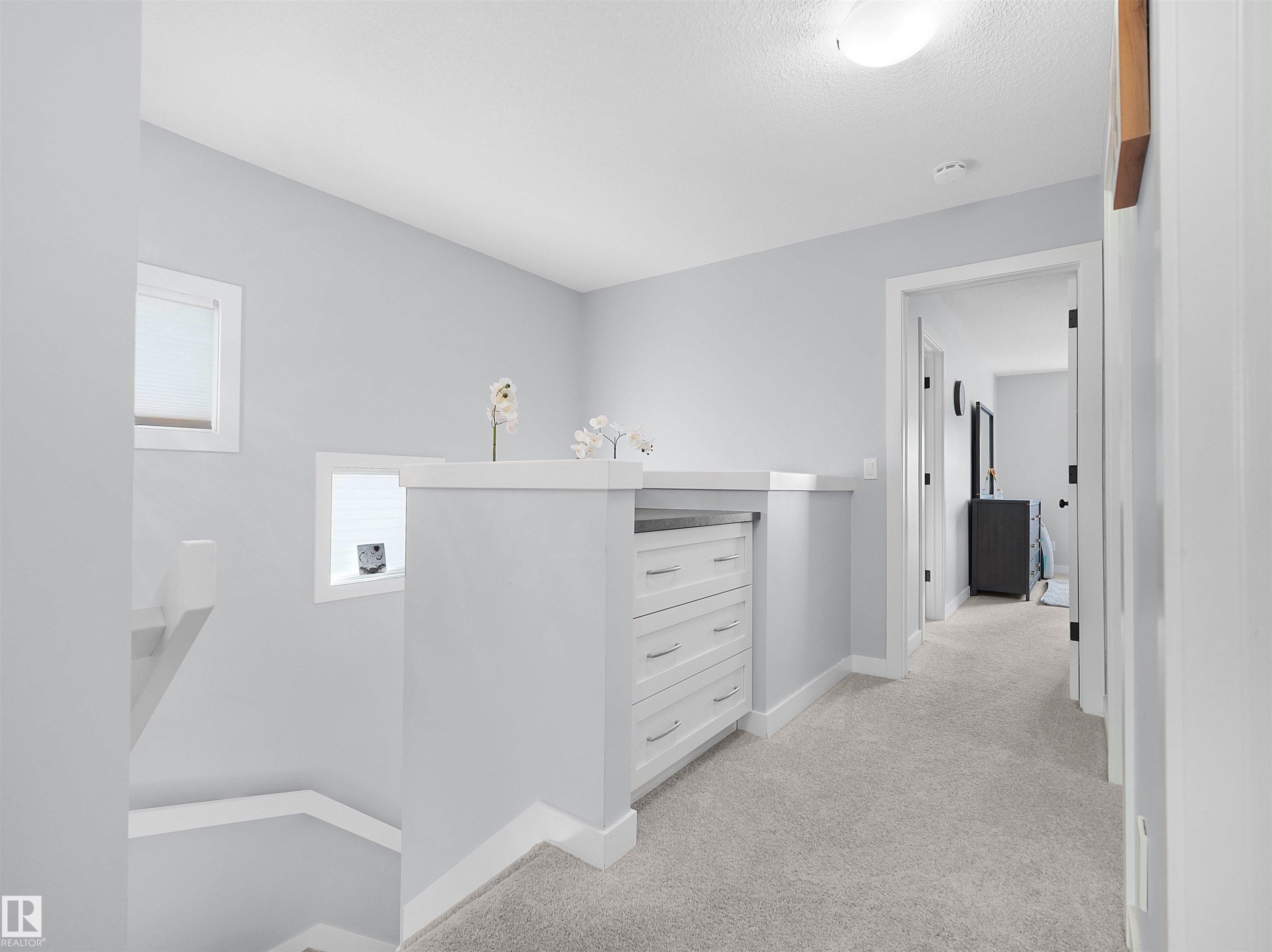 Built-in dresser with white cabinetry, polished hardware, and a durable countertop - 6656 Cardinal Rd Sw, Edmonton, AB