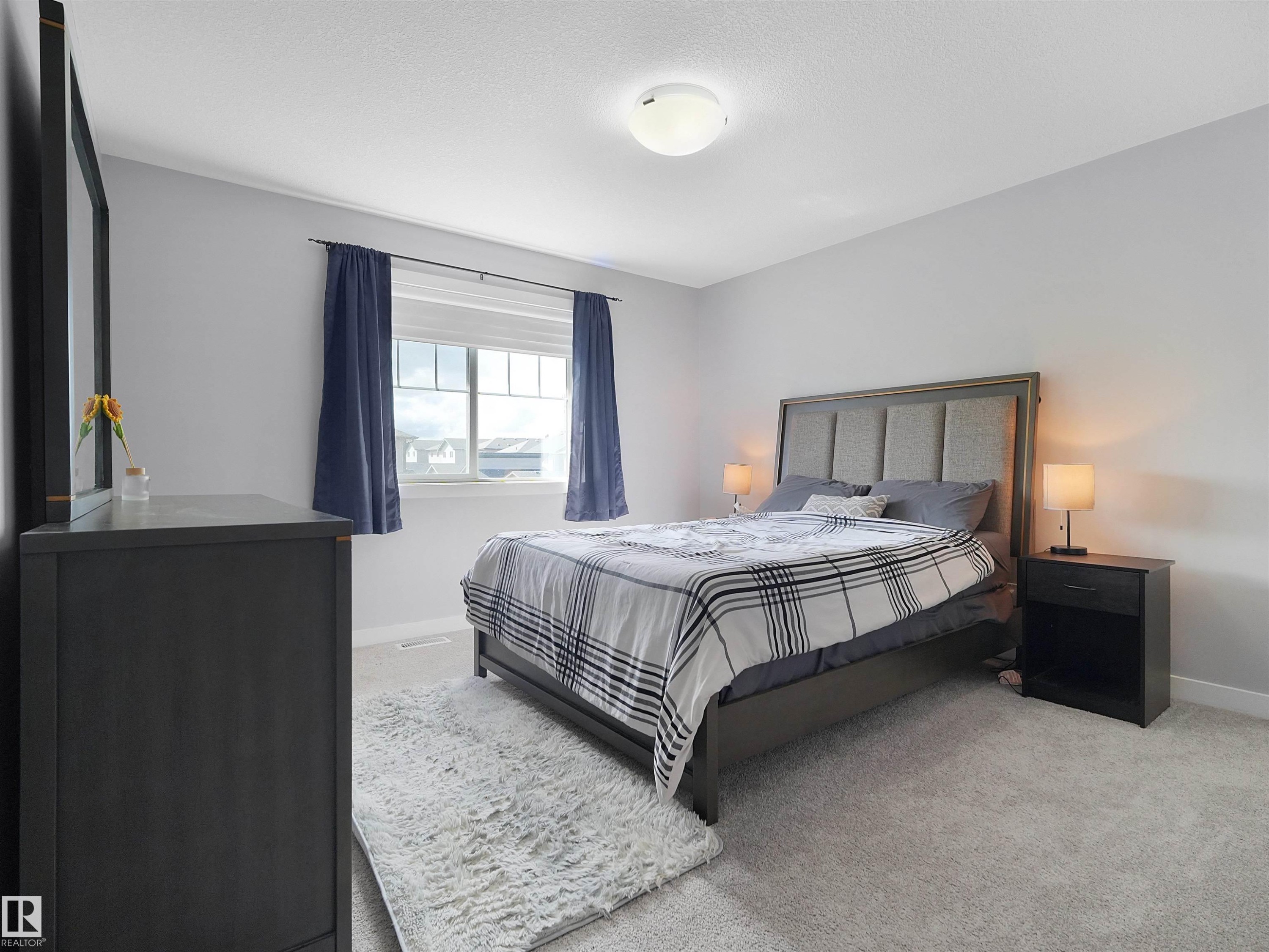 Neutral wall paint with textured carpeting, and a window featuring white trim and dark draperies - 6656 Cardinal Rd Sw, Edmonton, AB
