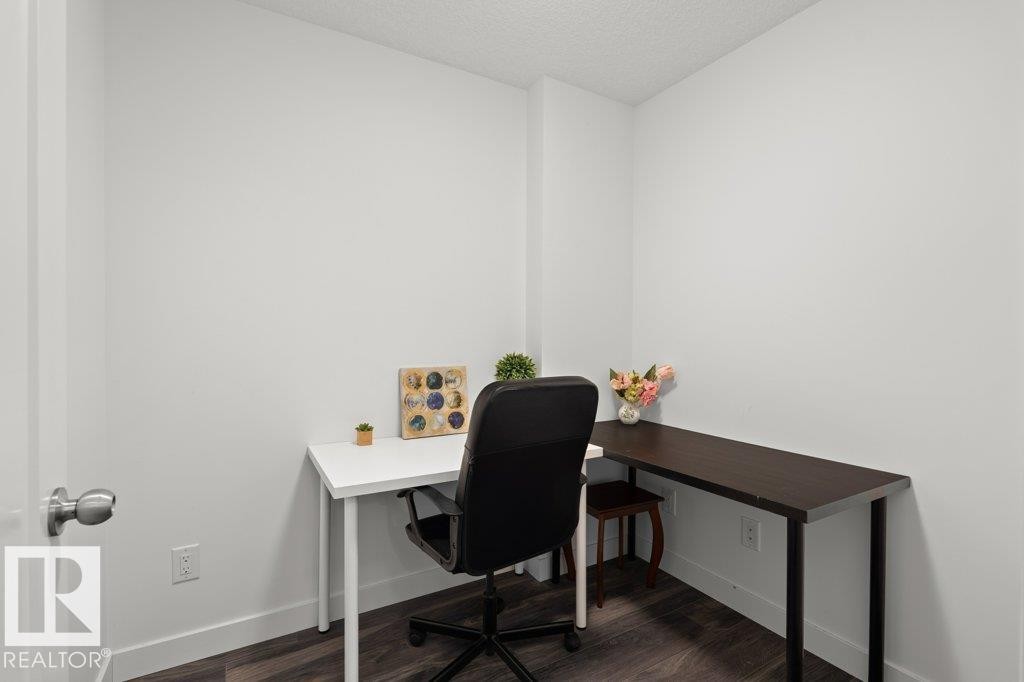 Compact room with dark wood-finish flooring, white walls, and bright white trim - 1316 Windermere Way Sw, Edmonton, AB