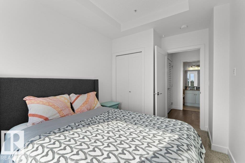 Bedroom featuring neutral carpeting and a tray ceiling detail - 1316 Windermere Way Sw, Edmonton, AB