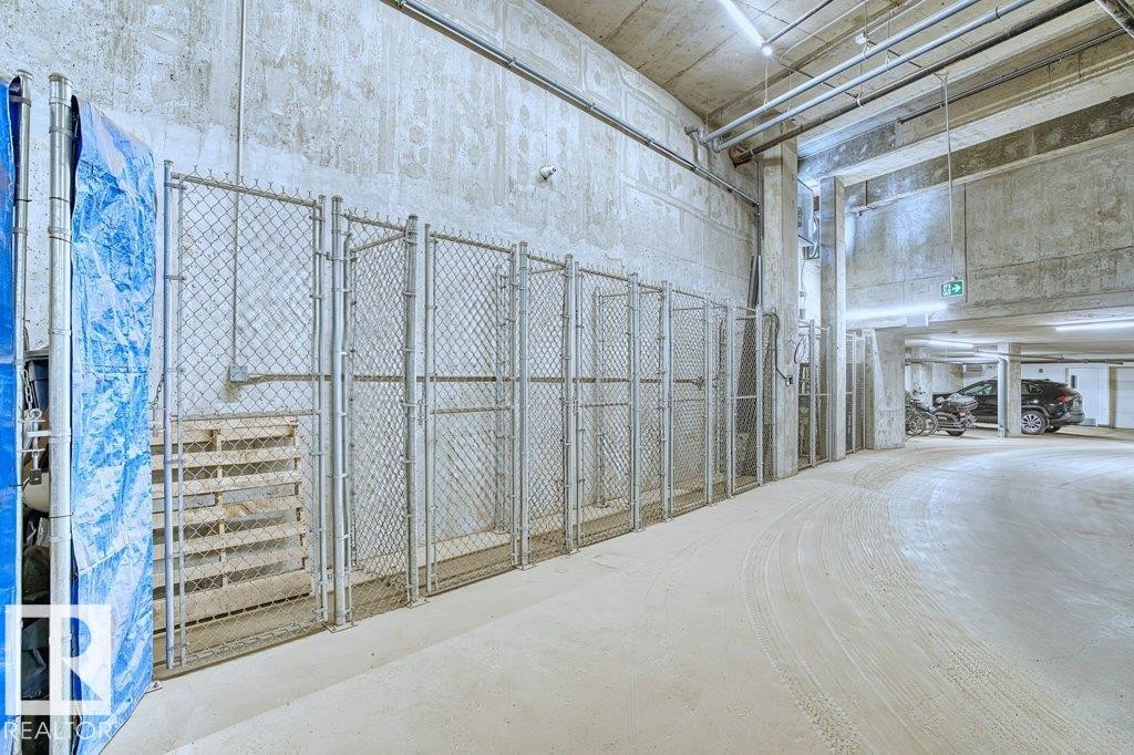 Underground parking facility featuring exposed concrete walls and ceiling - 1316 Windermere Way Sw, Edmonton, AB