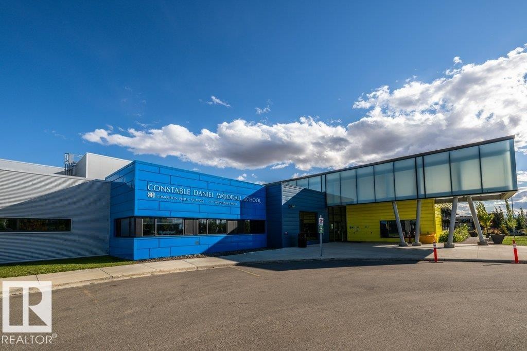 Modern institutional architecture featuring blue and yellow facade panels - 1316 Windermere Way Sw, Edmonton, AB