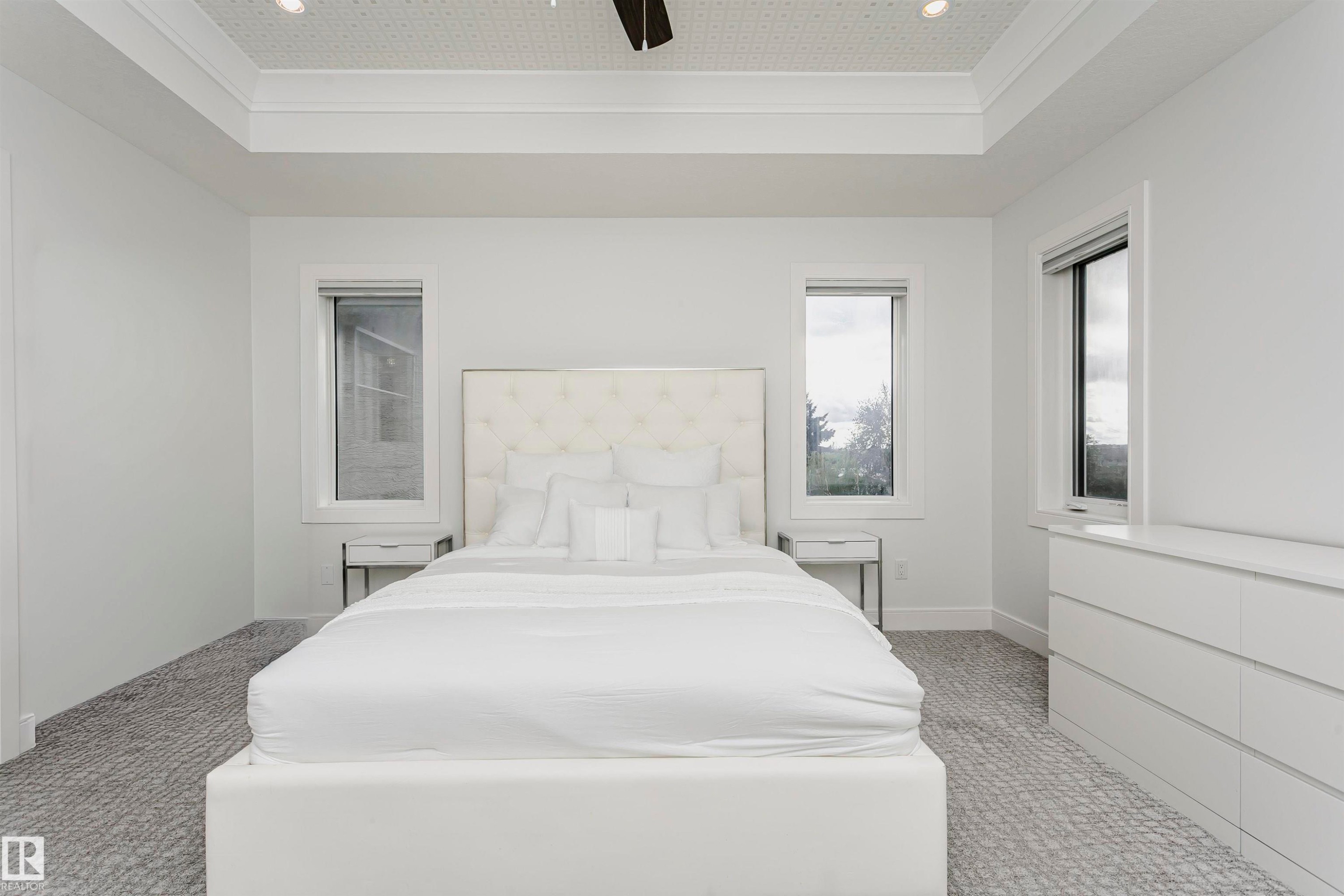 Tray ceiling with recessed lighting, patterned carpet flooring, and multiple windows - 9107 181 Avenue Nw, Edmonton, AB