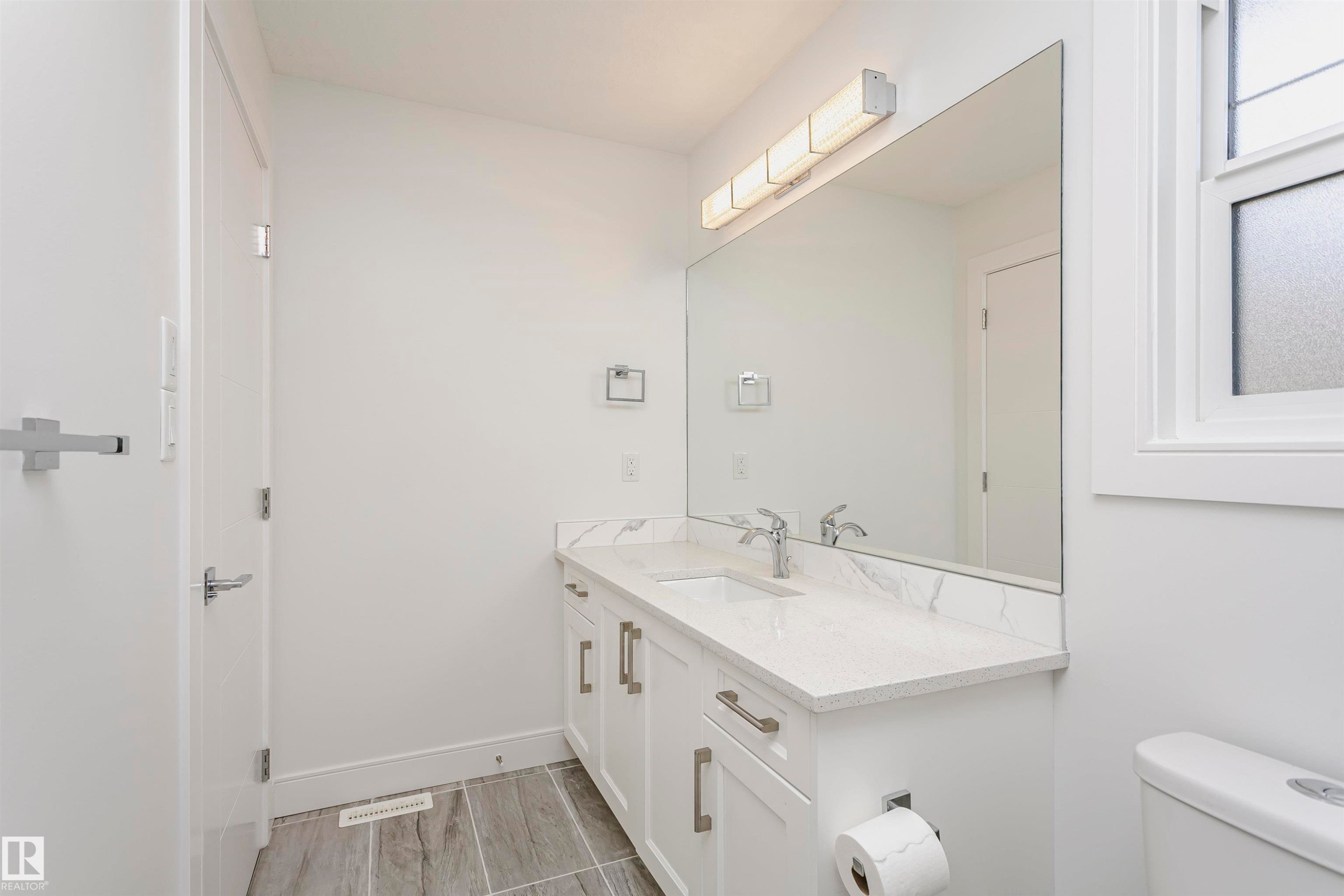 Dual vanity with white cabinetry, polished chrome hardware, and undermount sinks - 9107 181 Avenue Nw, Edmonton, AB
