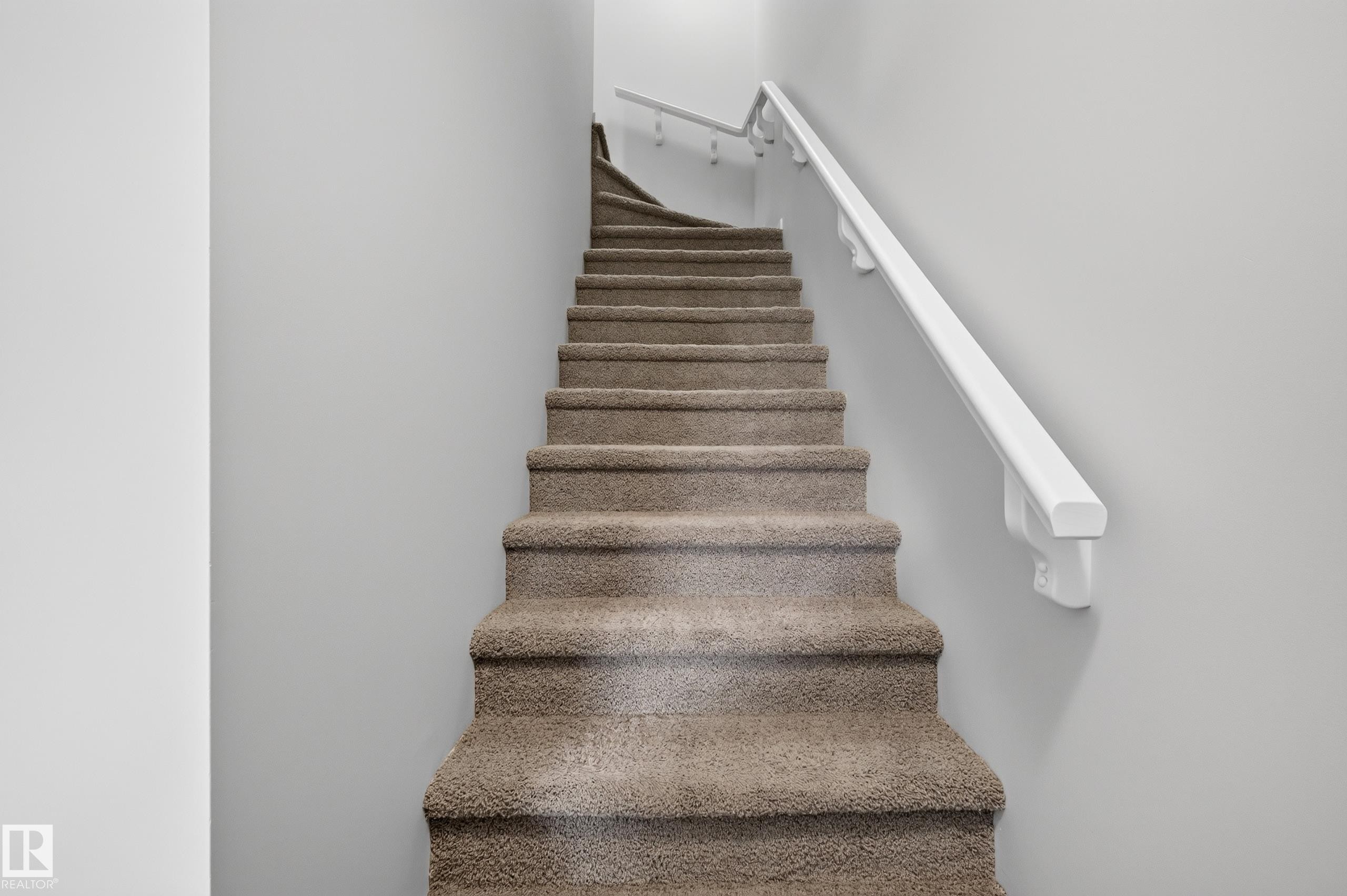 Carpeted staircase with white wall-mounted handrail - #72 603 Watt Bv Sw Sw, Edmonton, AB