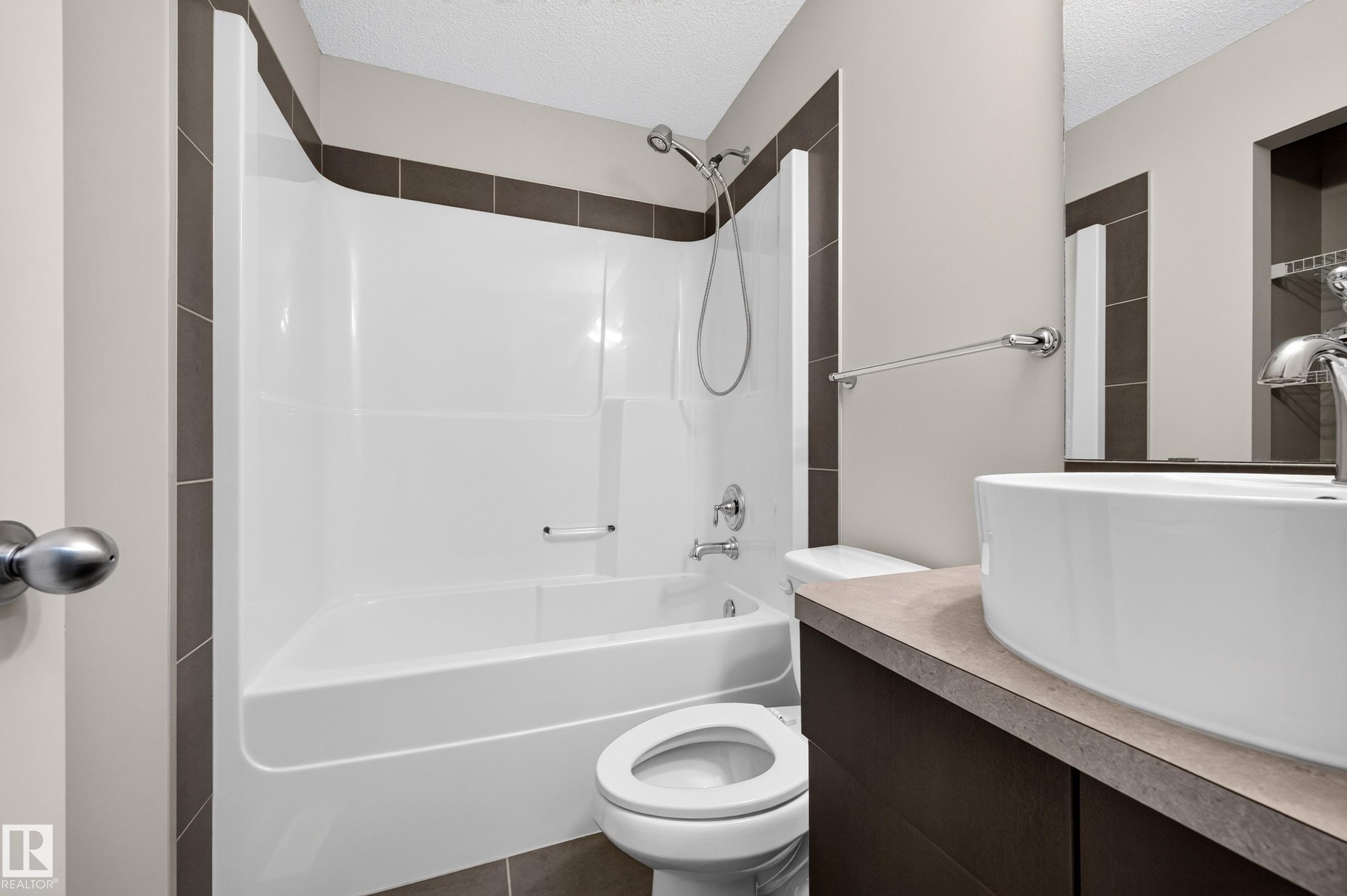 Full bathtub and shower combination with chrome fixtures, a vessel sink, and a dark wood-finish vanity - #72 603 Watt Bv Sw Sw, Edmonton, AB