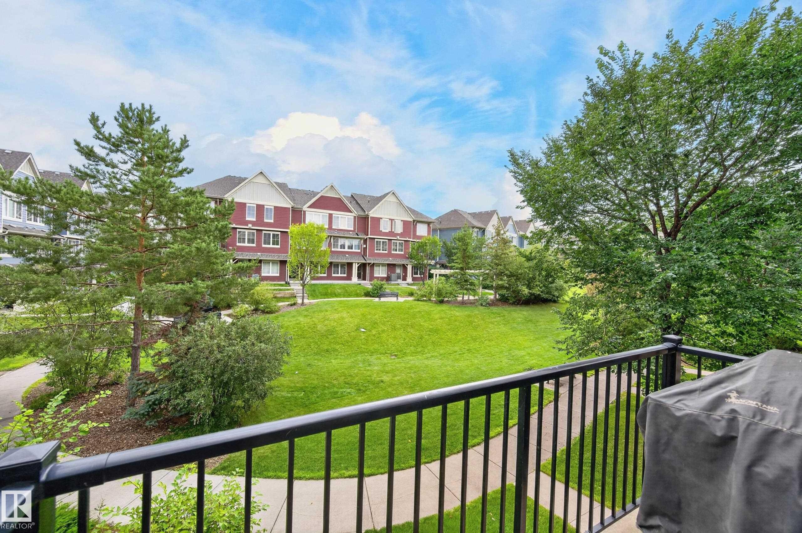 Expansive green space featuring mature trees and paved walking paths - #72 603 Watt Bv Sw Sw, Edmonton, AB