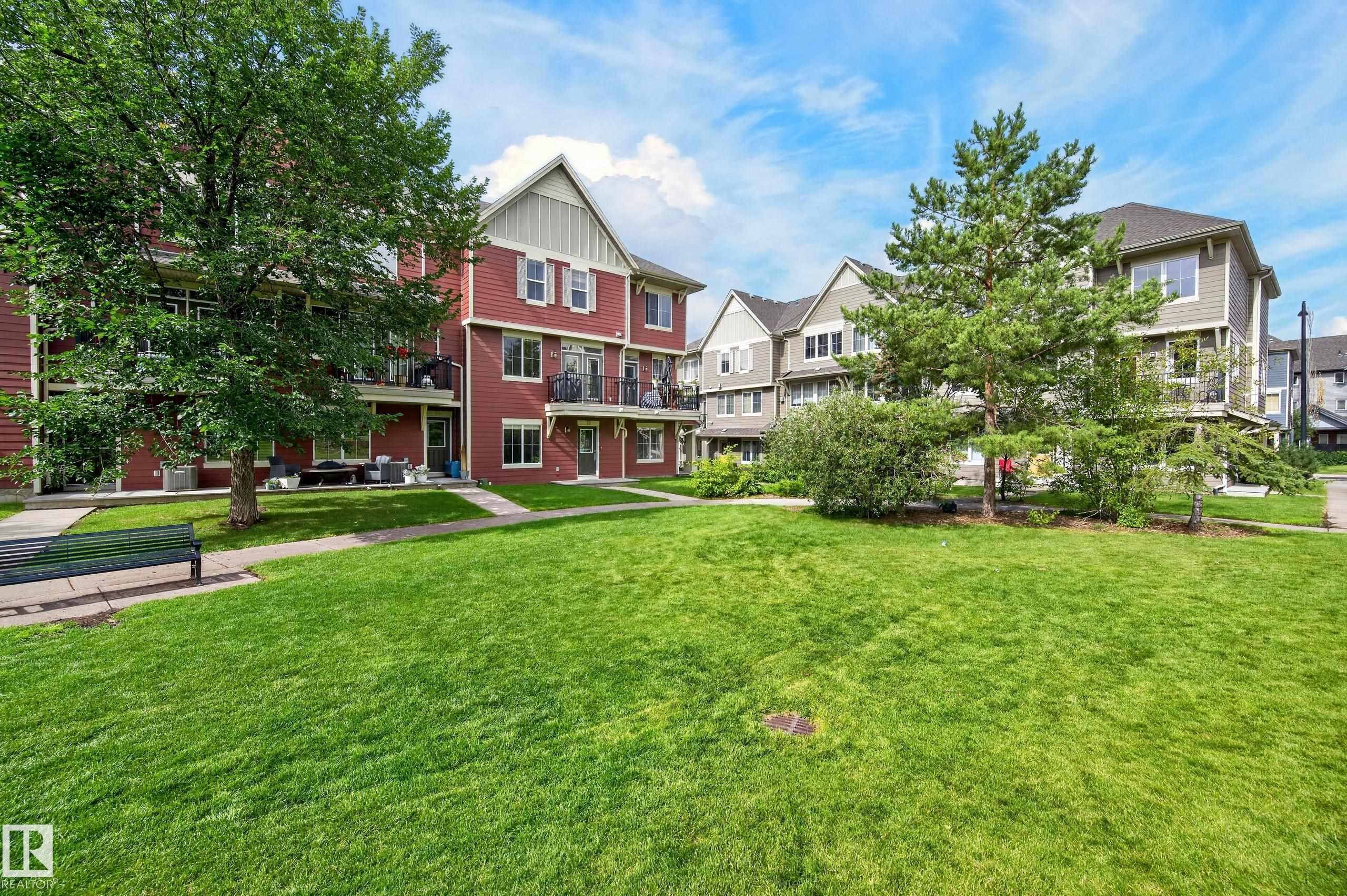 Expansive green space featuring mature trees and a paved walkway - #72 603 Watt Bv Sw Sw, Edmonton, AB