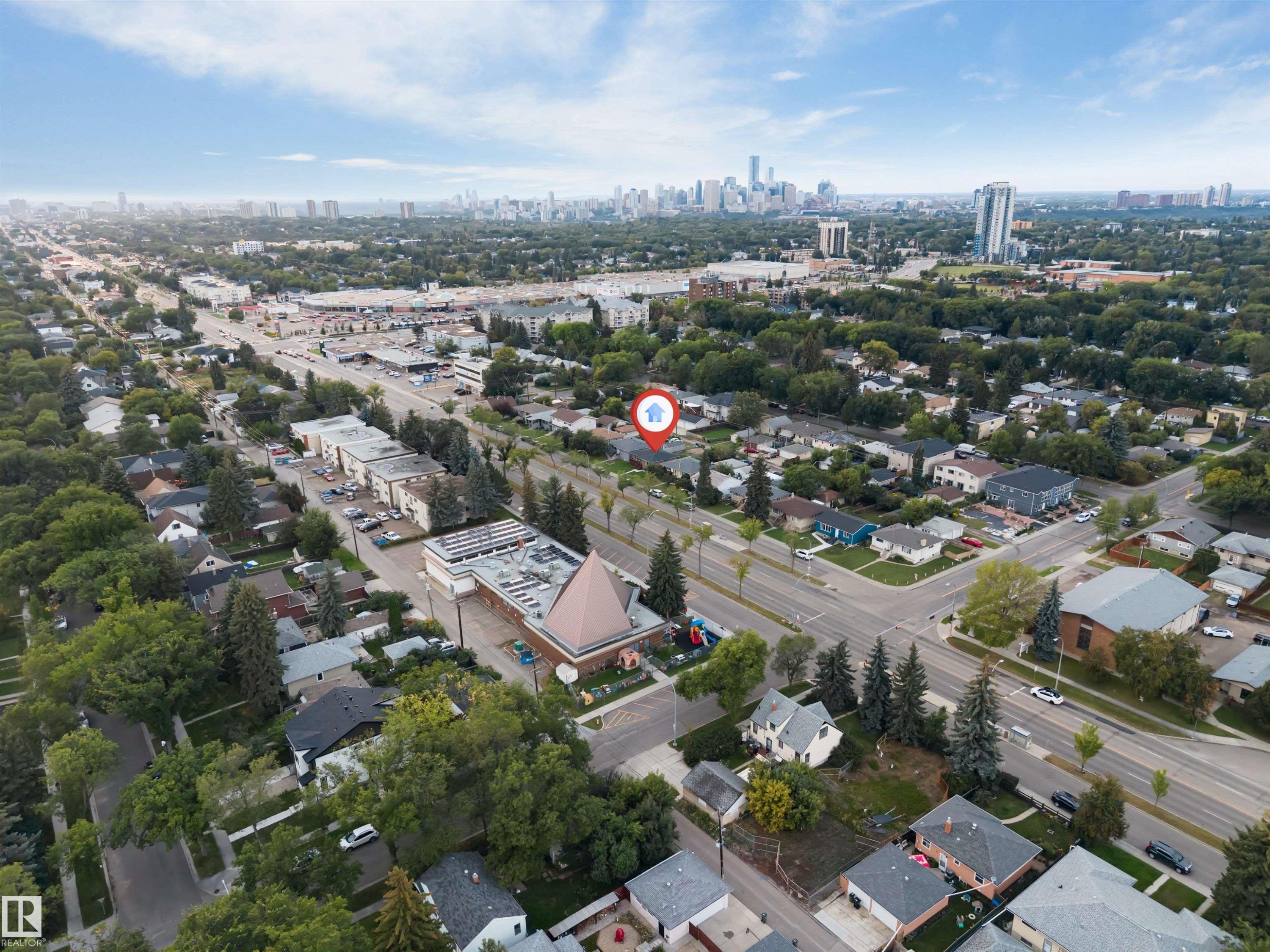 Aerial perspective showcasing residential streets, mature trees, and a distant city skyline - 7928 82 Avenue Nw, Edmonton, AB