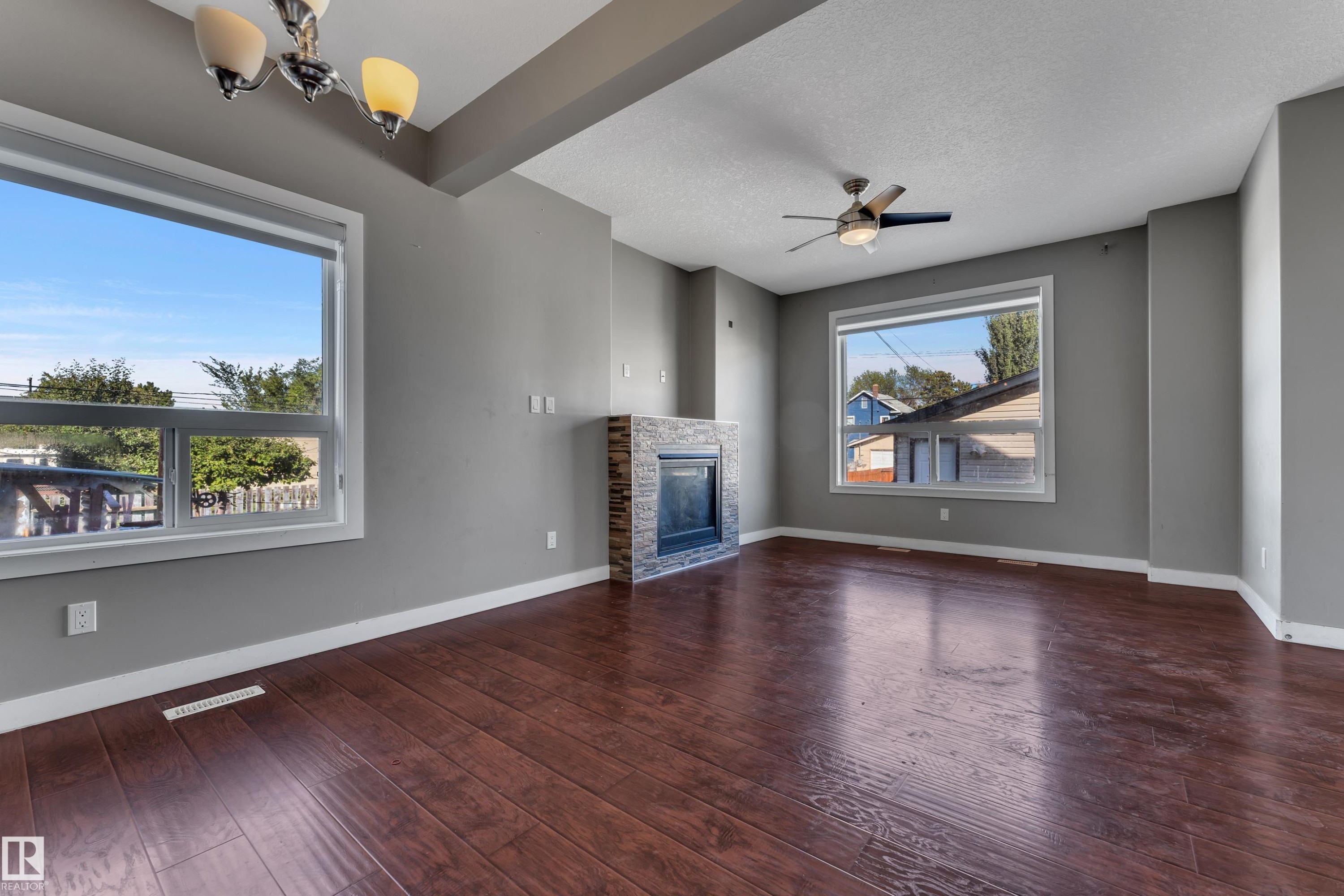 Wood-finish flooring, stone-clad fireplace, integrated ceiling fan, and recessed lighting - 11421 82 Street Nw, Edmonton, AB