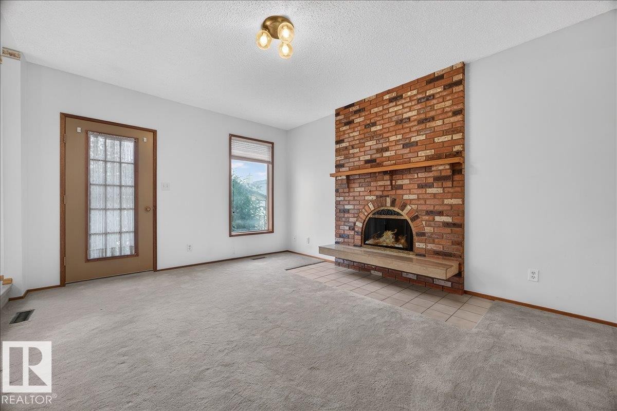Brick fireplace with an arched firebox and wood mantel - 2907 49 Street Nw, Edmonton, AB
