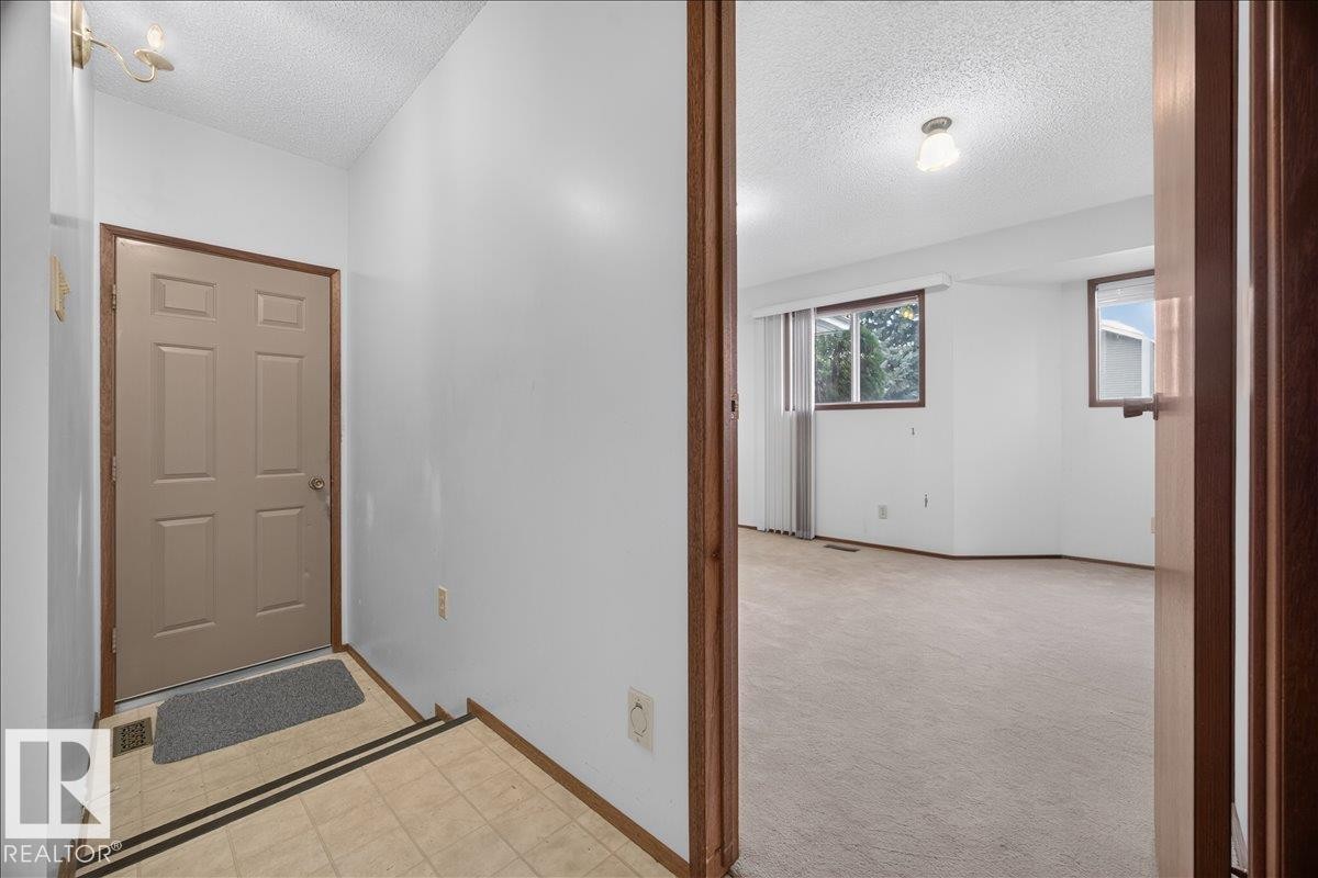 Tiled entryway with a neutral-toned door and wood-finish trim - 2907 49 Street Nw, Edmonton, AB