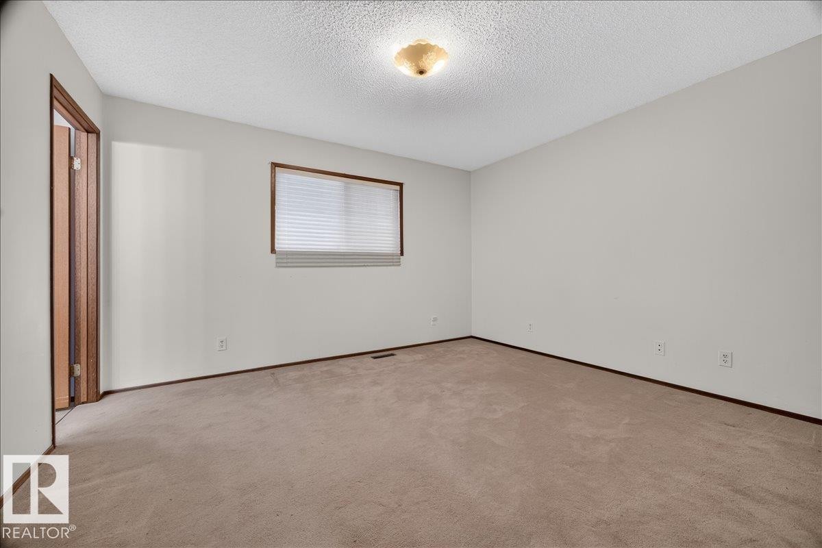 Carpeted flooring, white walls, wood-finish trim, window with blinds, and ceiling-mounted light fixture - 2907 49 Street Nw, Edmonton, AB