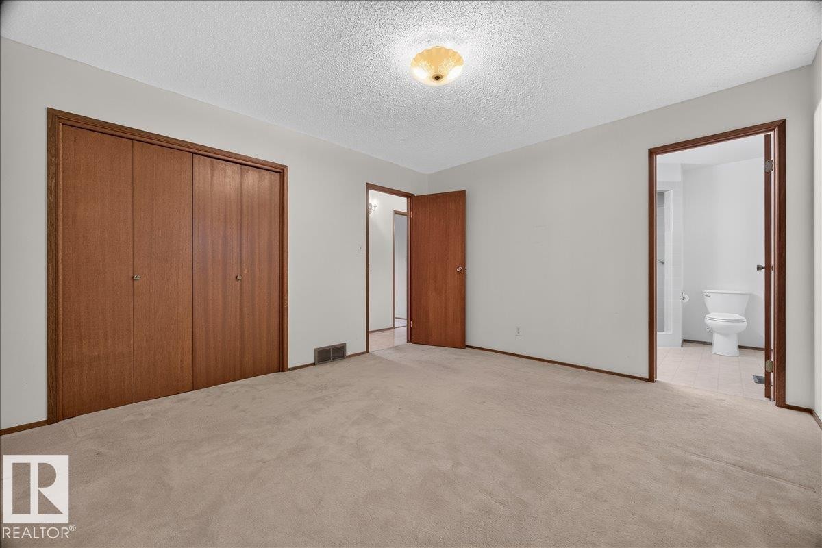 Neutral wall paint throughout, warm-toned wood doors, and light-colored carpeting - 2907 49 Street Nw, Edmonton, AB