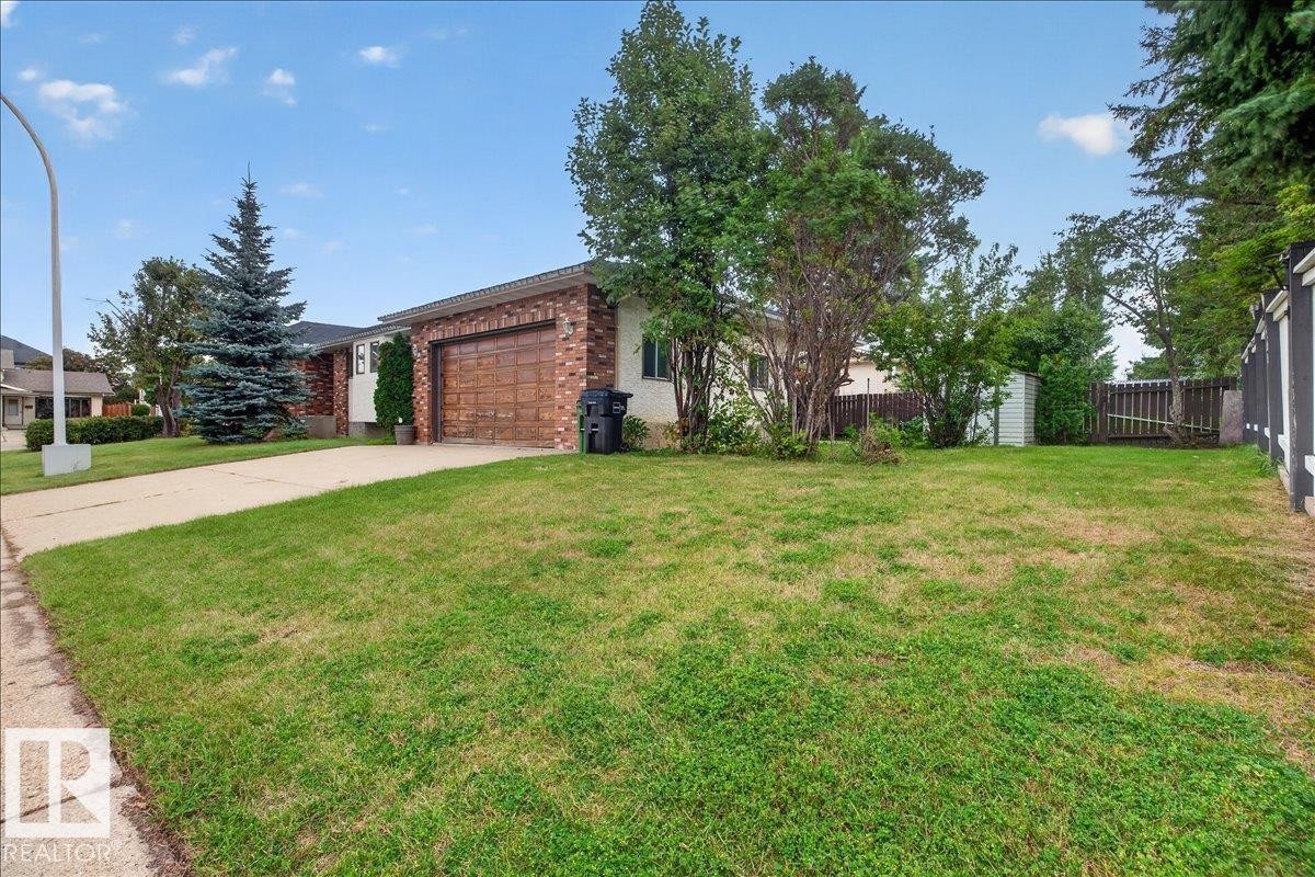 Brick facade with an attached garage, paved driveway, and mature landscaping - 2907 49 Street Nw, Edmonton, AB
