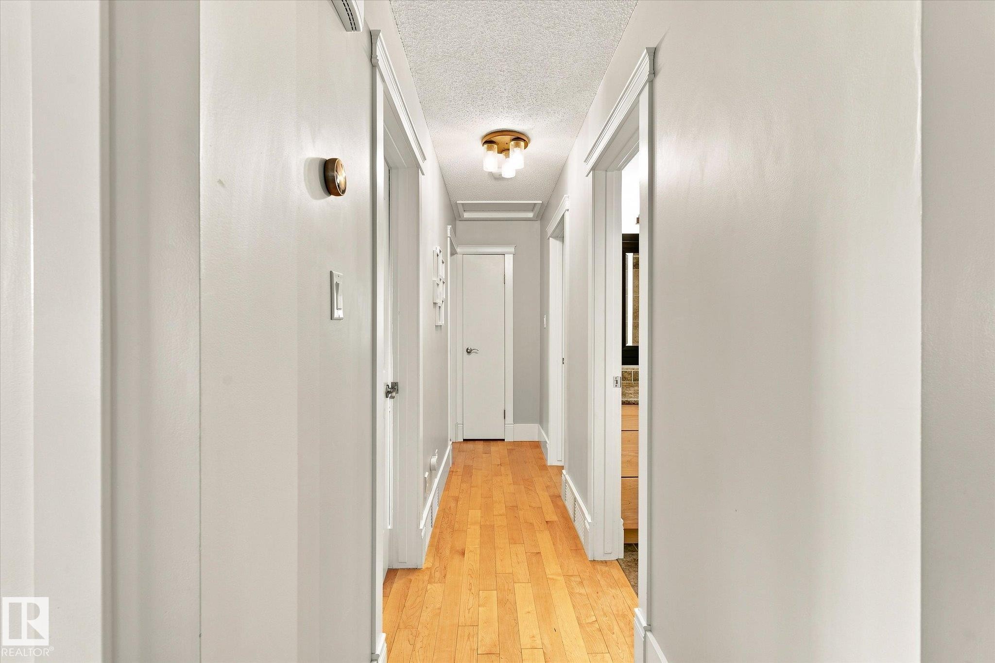 Hardwood flooring, brass ceiling light fixture, white interior doors, and white trim - 3 Akins Drive, St. Albert, AB