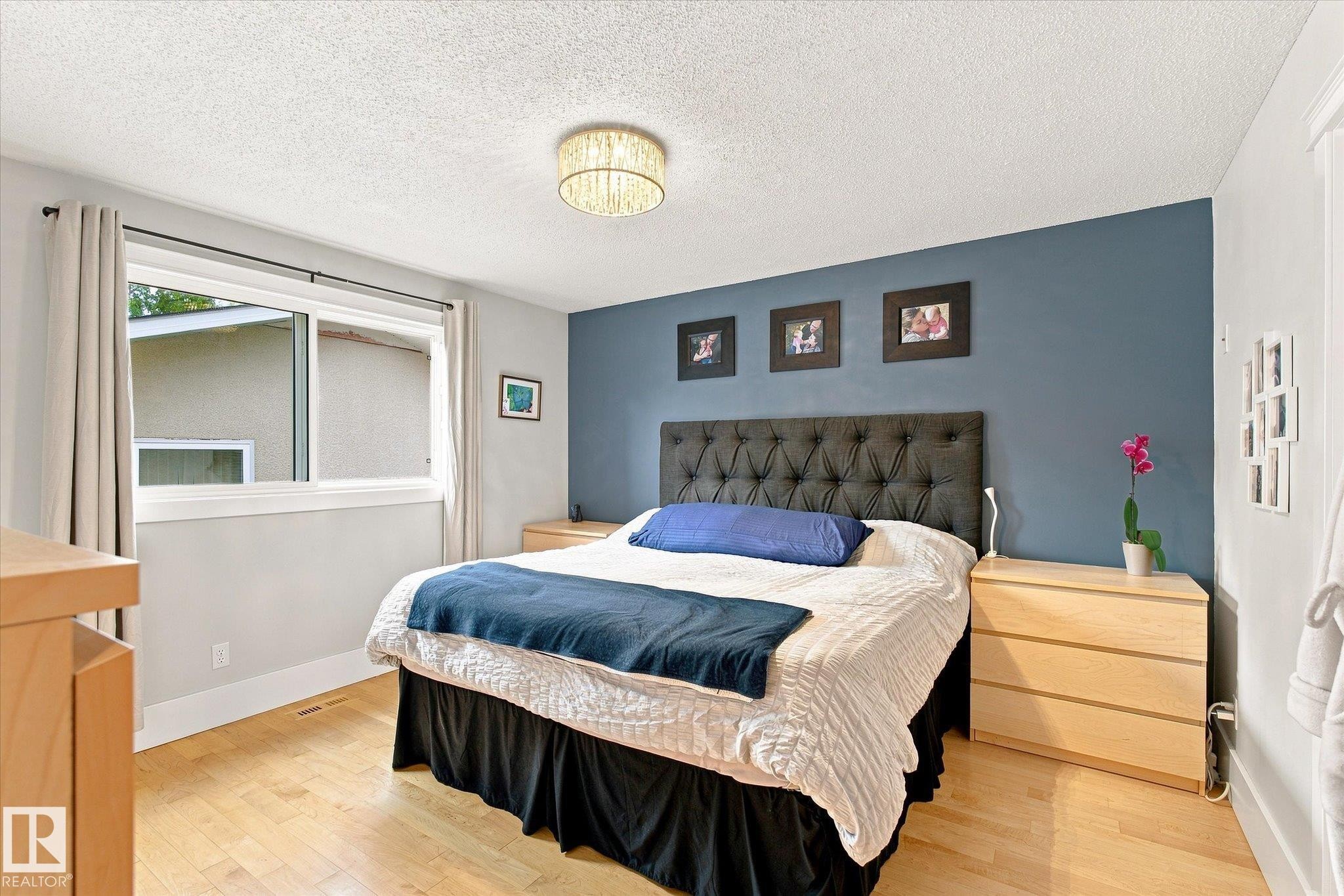 Wood-finish flooring, sliding window with white trim, and a contemporary ceiling light fixture - 3 Akins Drive, St. Albert, AB
