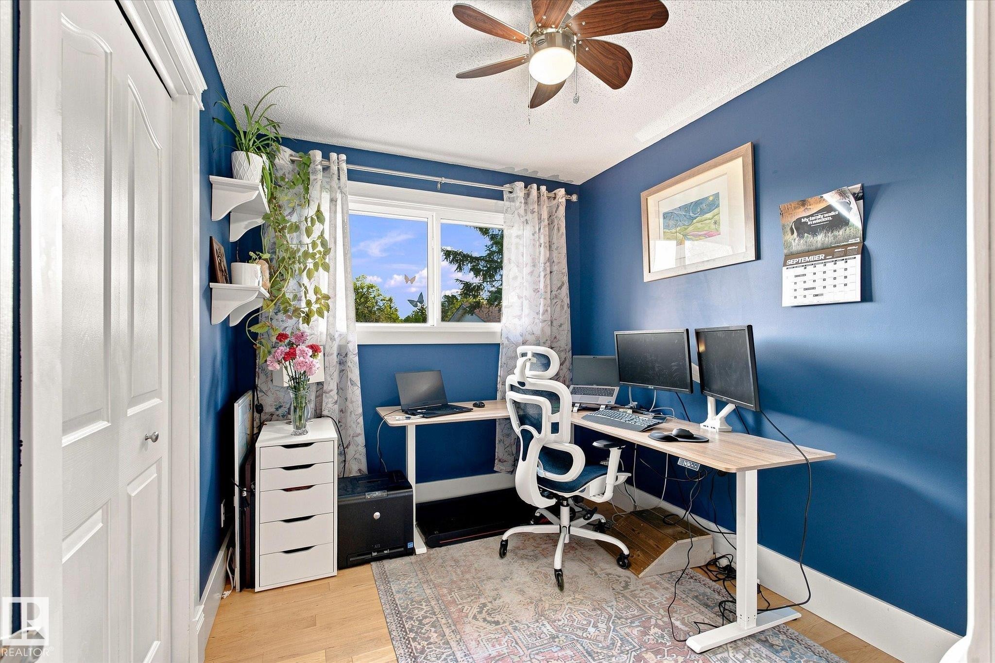 Bright room featuring an exterior window, wood-finish flooring, white trim, and a ceiling fan - 3 Akins Drive, St. Albert, AB