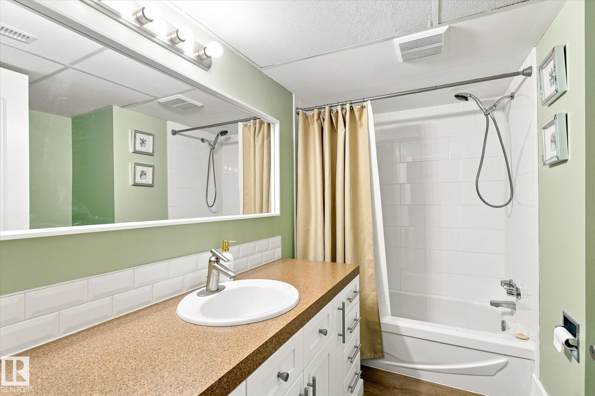 White vanity with brushed nickel hardware, integrated sink, and speckled countertop - 3 Akins Drive, St. Albert, AB