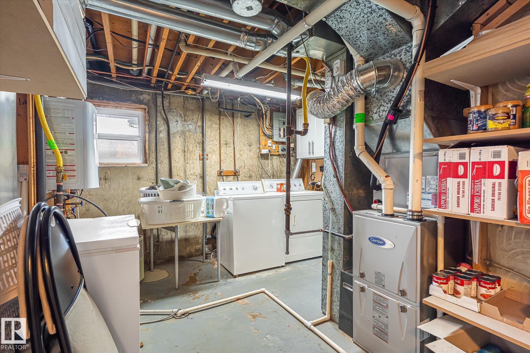 Laundry area with a window, exposed ceiling joists, utility shelving, and a Carrier HVAC system - 3 Akins Drive, St. Albert, AB