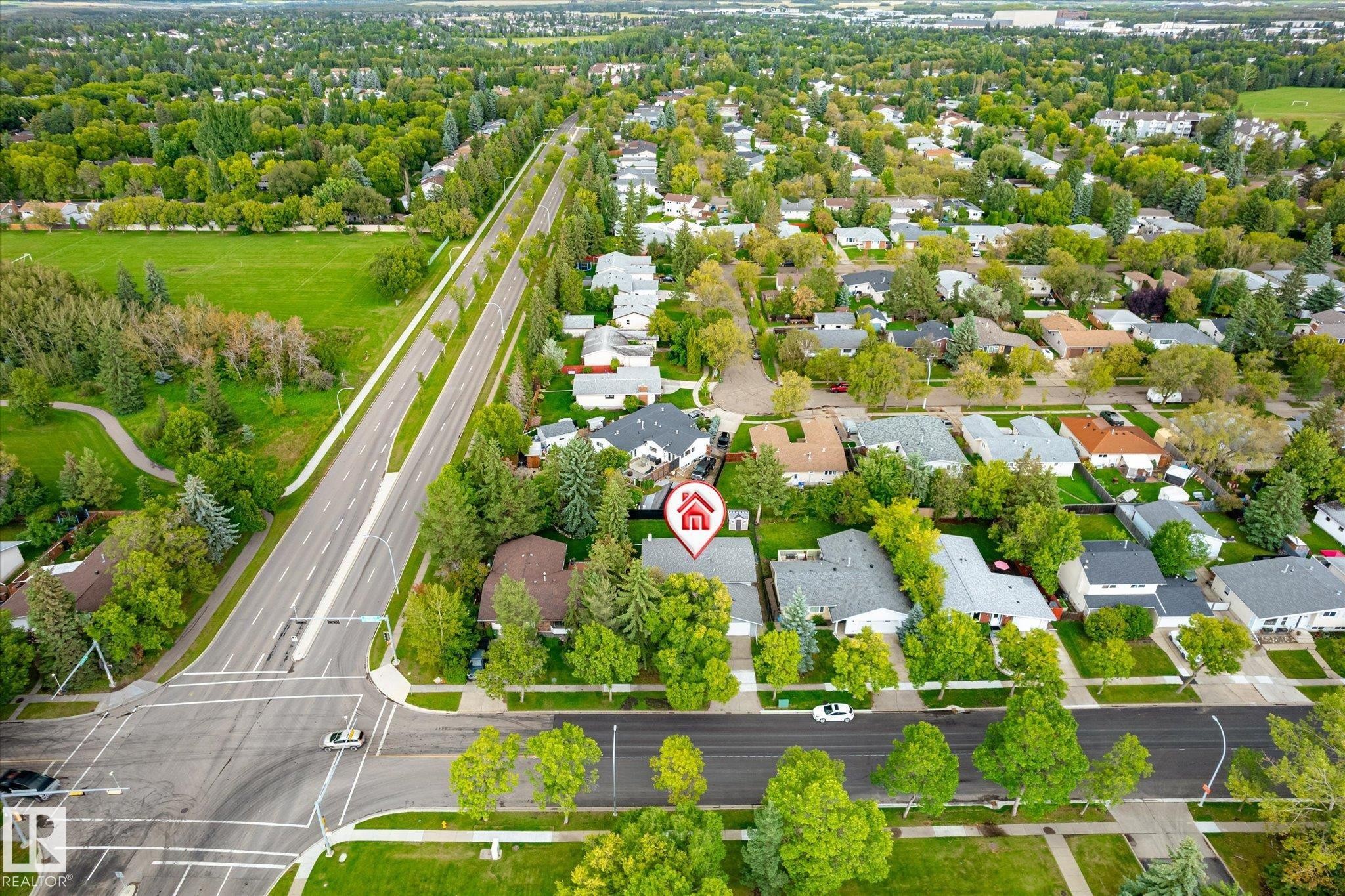 Aerial perspective showcasing residential properties, tree-lined streets, and expansive green spaces - 3 Akins Drive, St. Albert, AB