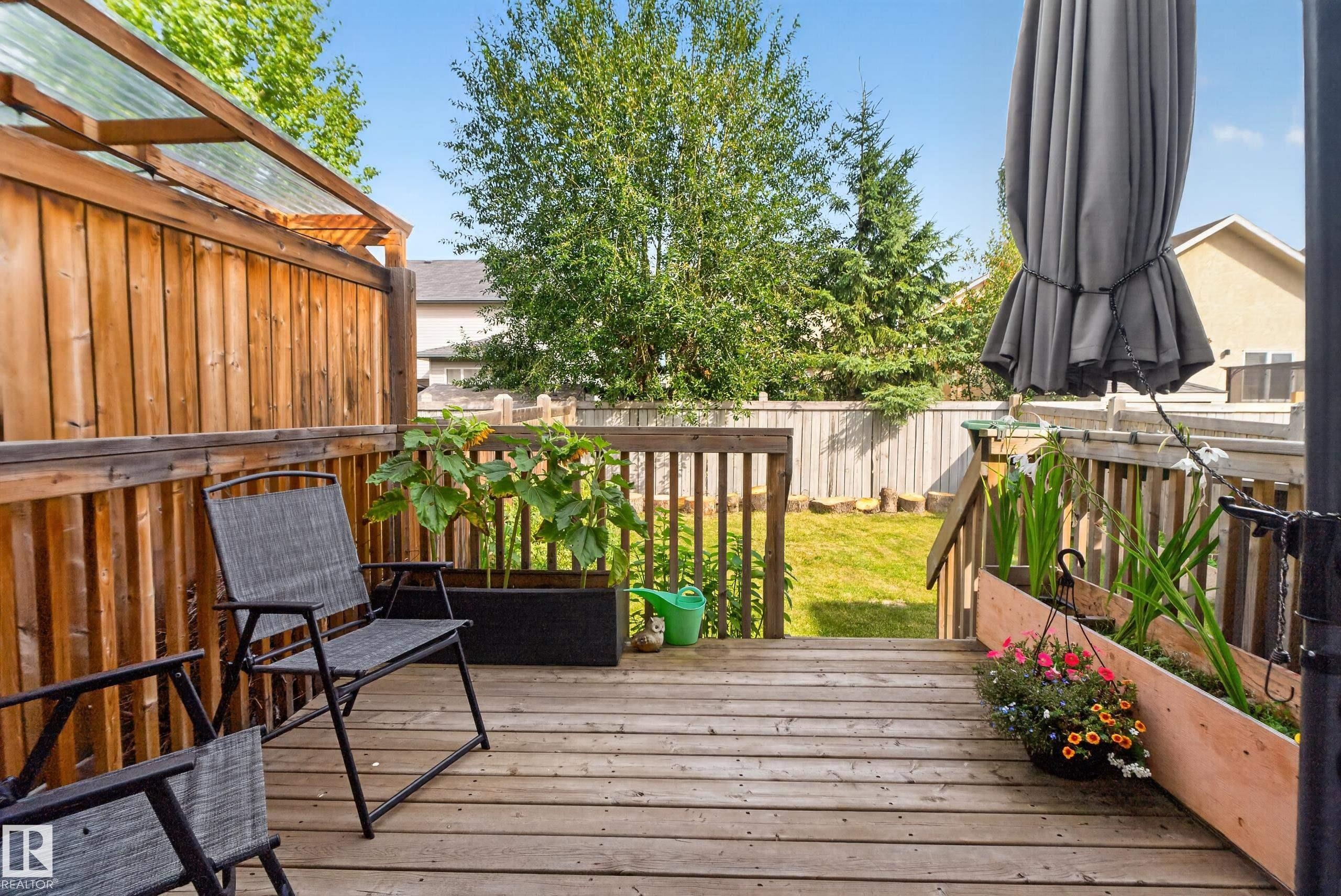 Wood-plank deck with railing, integrated planters, and a privacy fence - 17363 120 Street Nw, Edmonton, AB