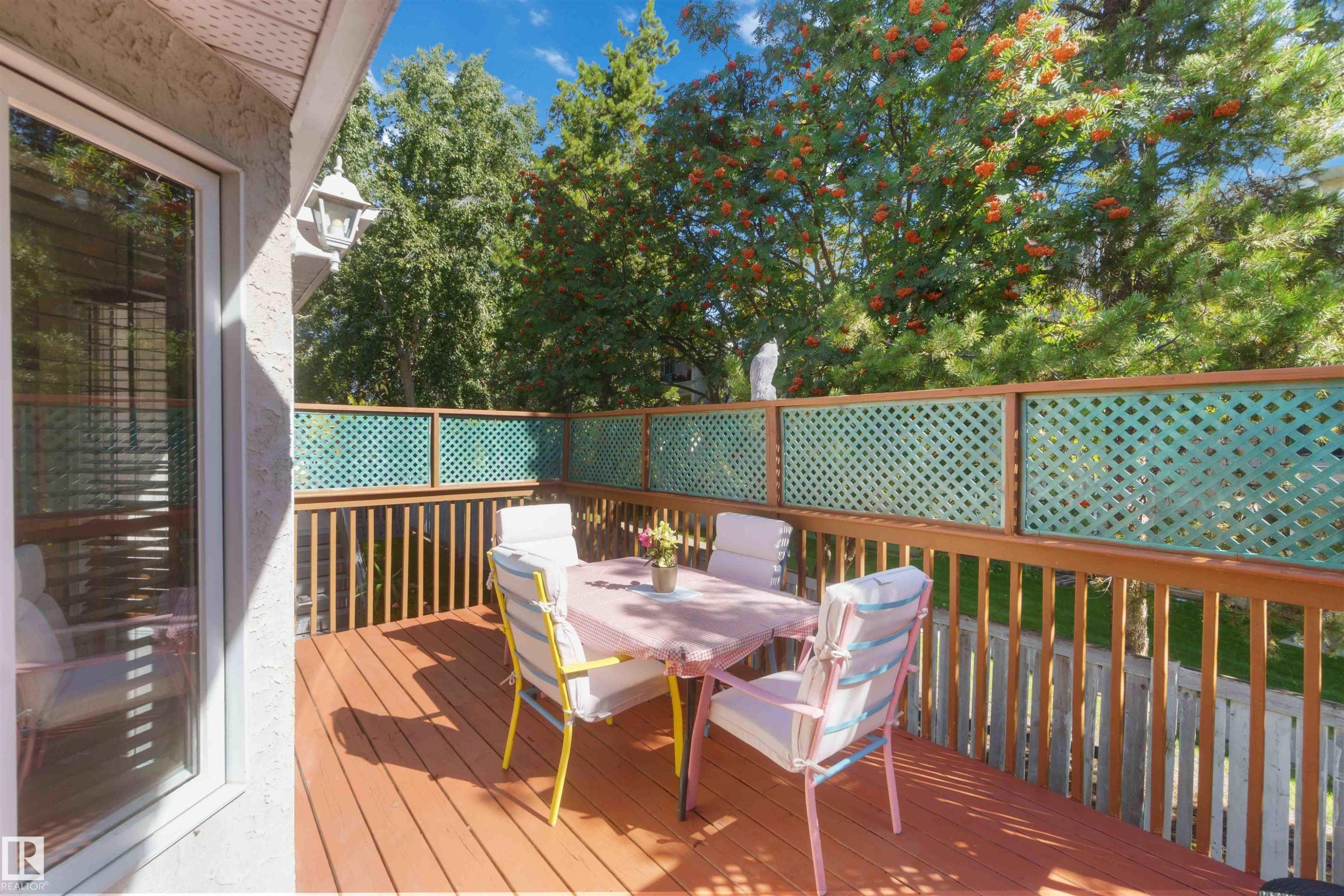 Wood-finish deck with a lattice privacy screen and a wood railing - #6 15 Poirier Av, St. Albert, AB