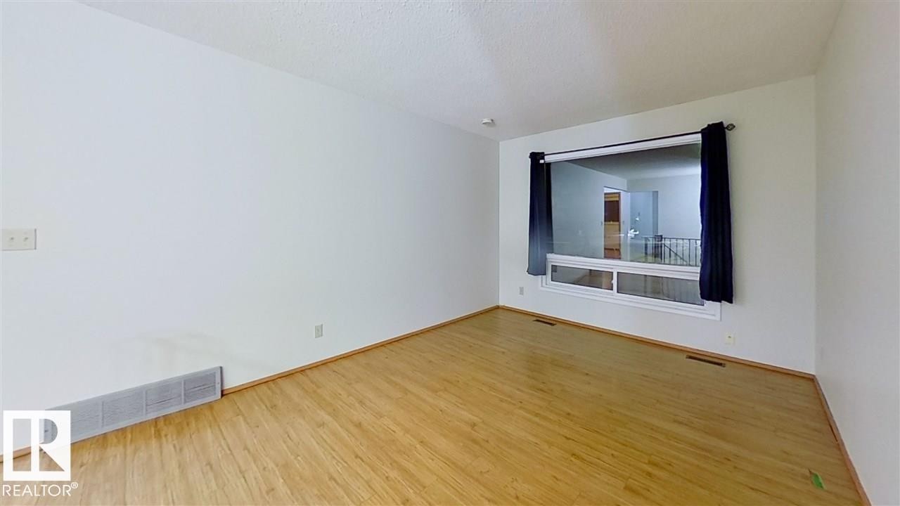 Wood-finish flooring with white baseboards - 4611 52 Avenue, Stony Plain, AB