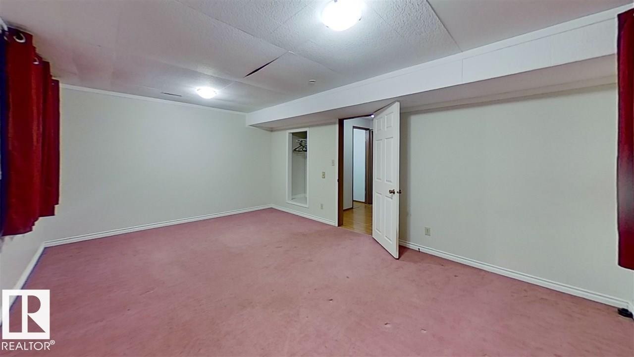 Expansive room with wall-to-wall carpeting, light-toned walls, overhead lighting, and an open doorway - 4611 52 Avenue, Stony Plain, AB