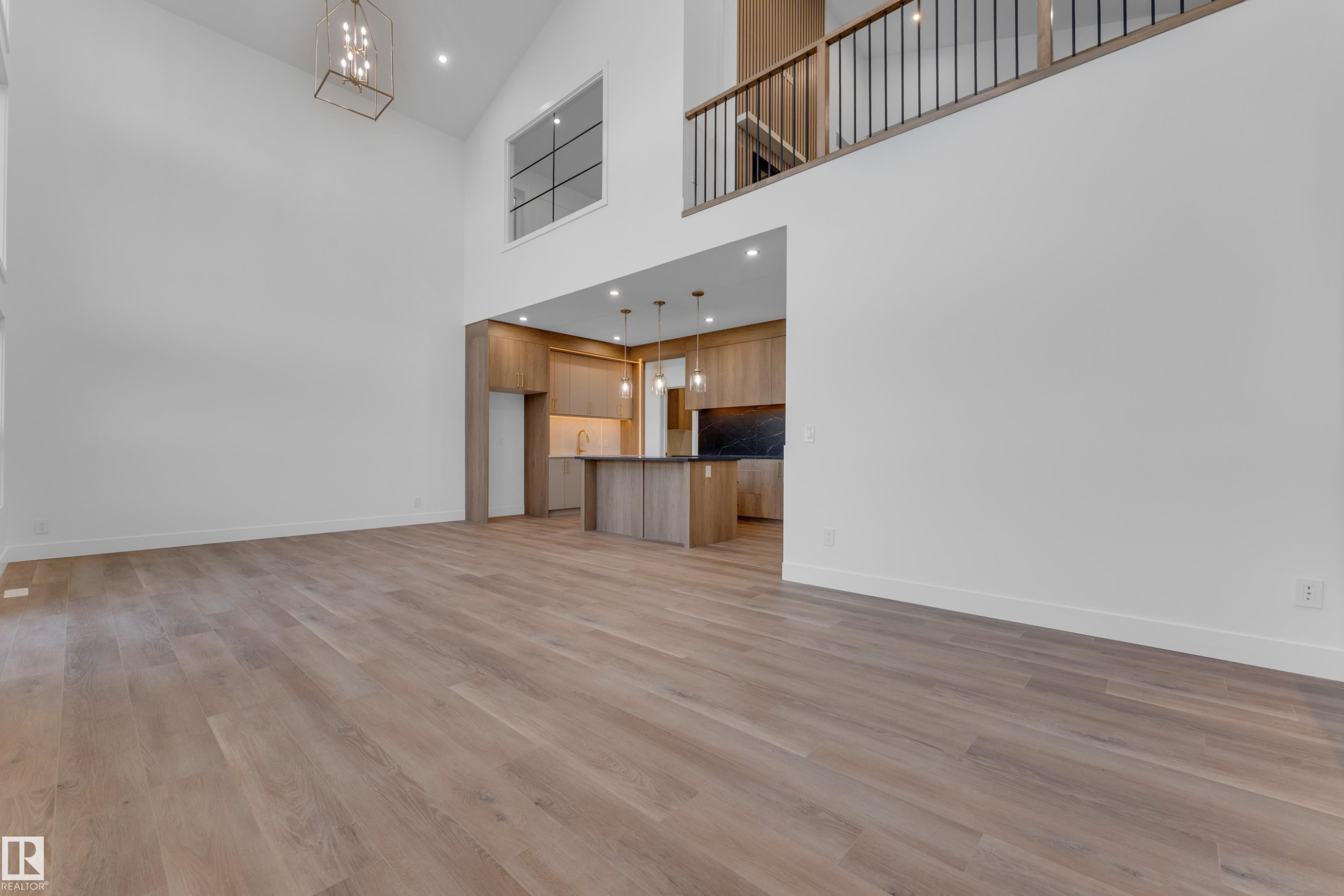 Vaulted ceiling, open-concept design, wood-finish flooring, contemporary kitchen cabinetry, and a second-level open railing - 236 Linden Loop, Leduc, AB