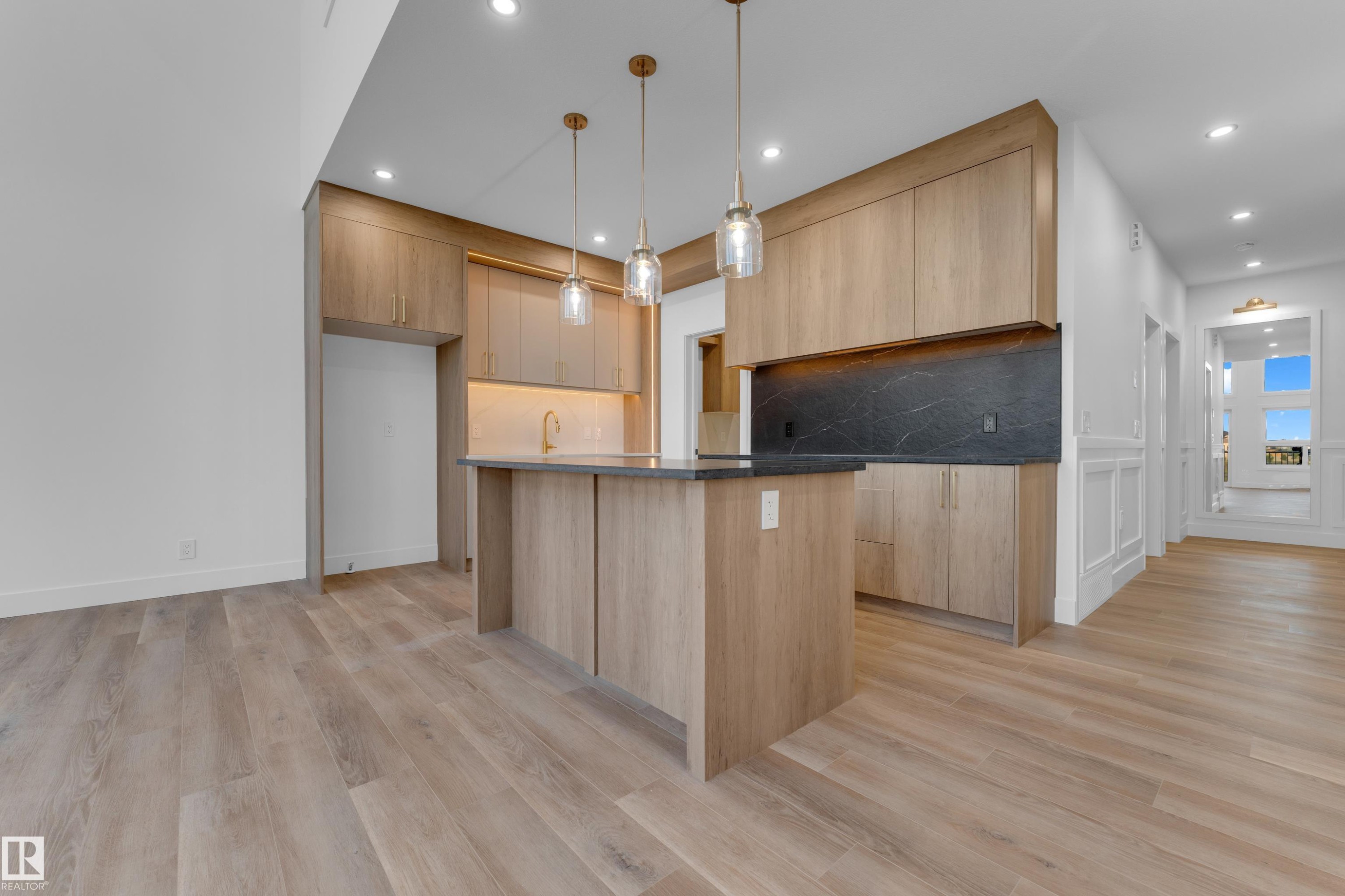 Open-concept kitchen with wood-finish cabinetry, a central island, recessed lighting, and pendant fixtures - 236 Linden Loop, Leduc, AB