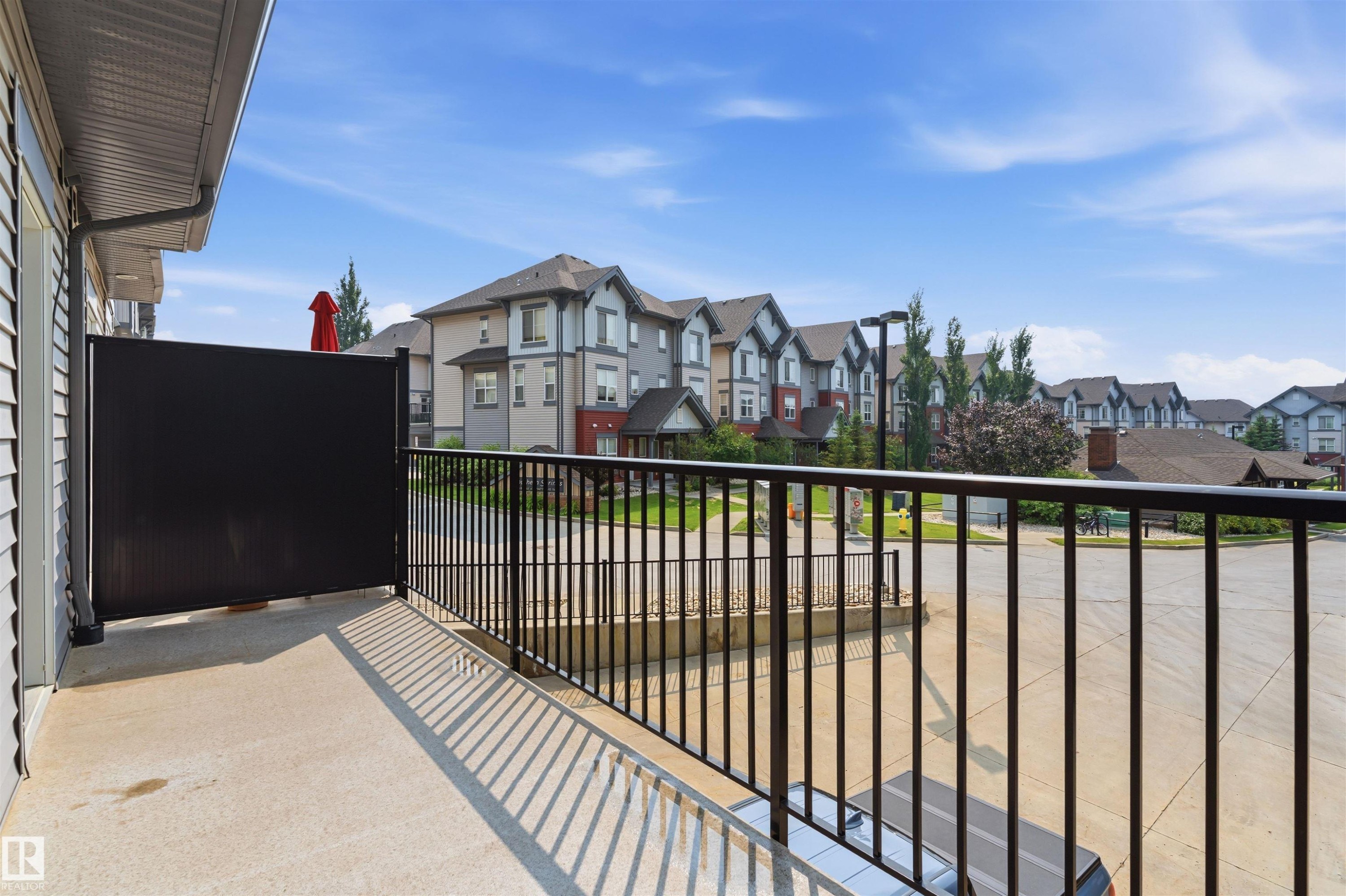 Private balcony with concrete flooring, black metal railing, and a privacy screen - #62 675 Watt Bv Sw, Edmonton, AB